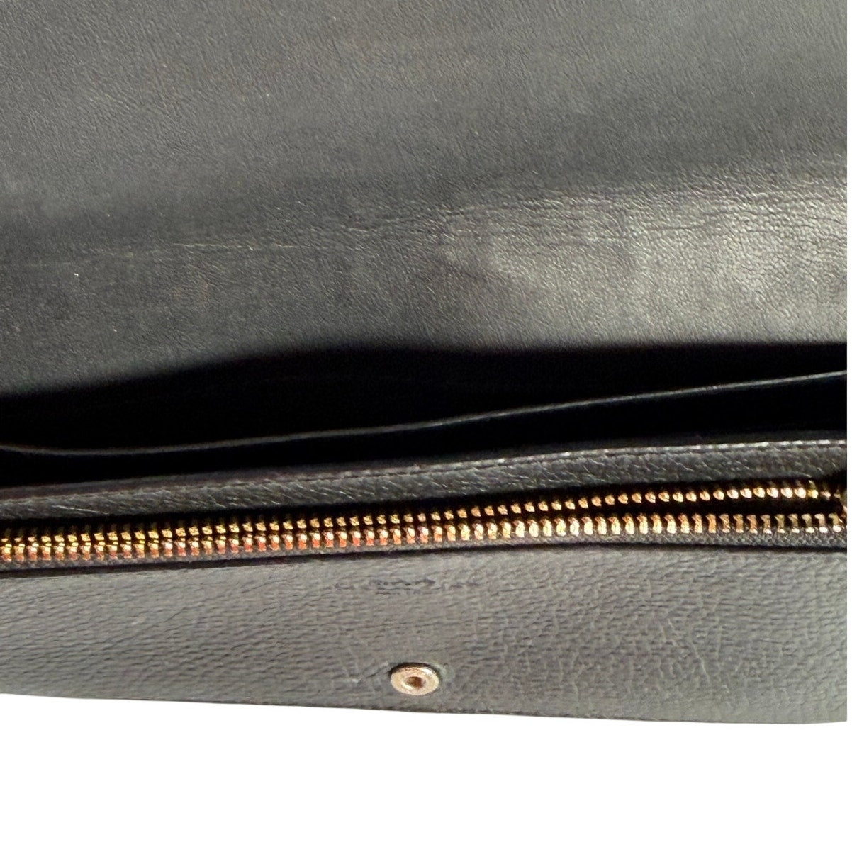 Coach women's black leather foldover crossbody wallet bag with adjustable strap, showcasing its sleek design and compact style.