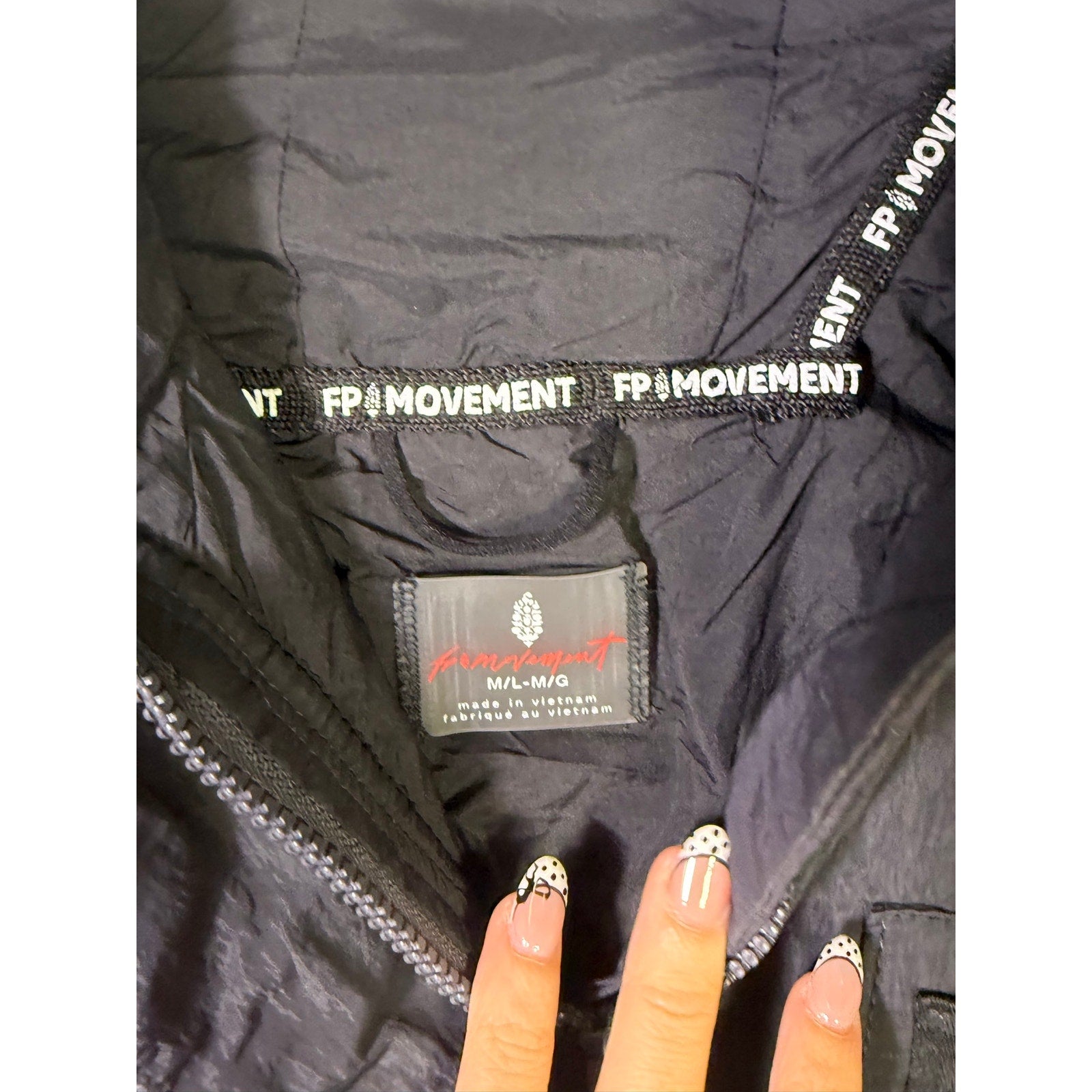 Black hooded utility jacket for women by Free People, featuring a hoodie and functional pockets, size M/L.
