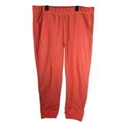 On Running women's ribbed coral orange jogger sweatpants in size XL, showing the fitted elastic waistband and ribbed fabric.