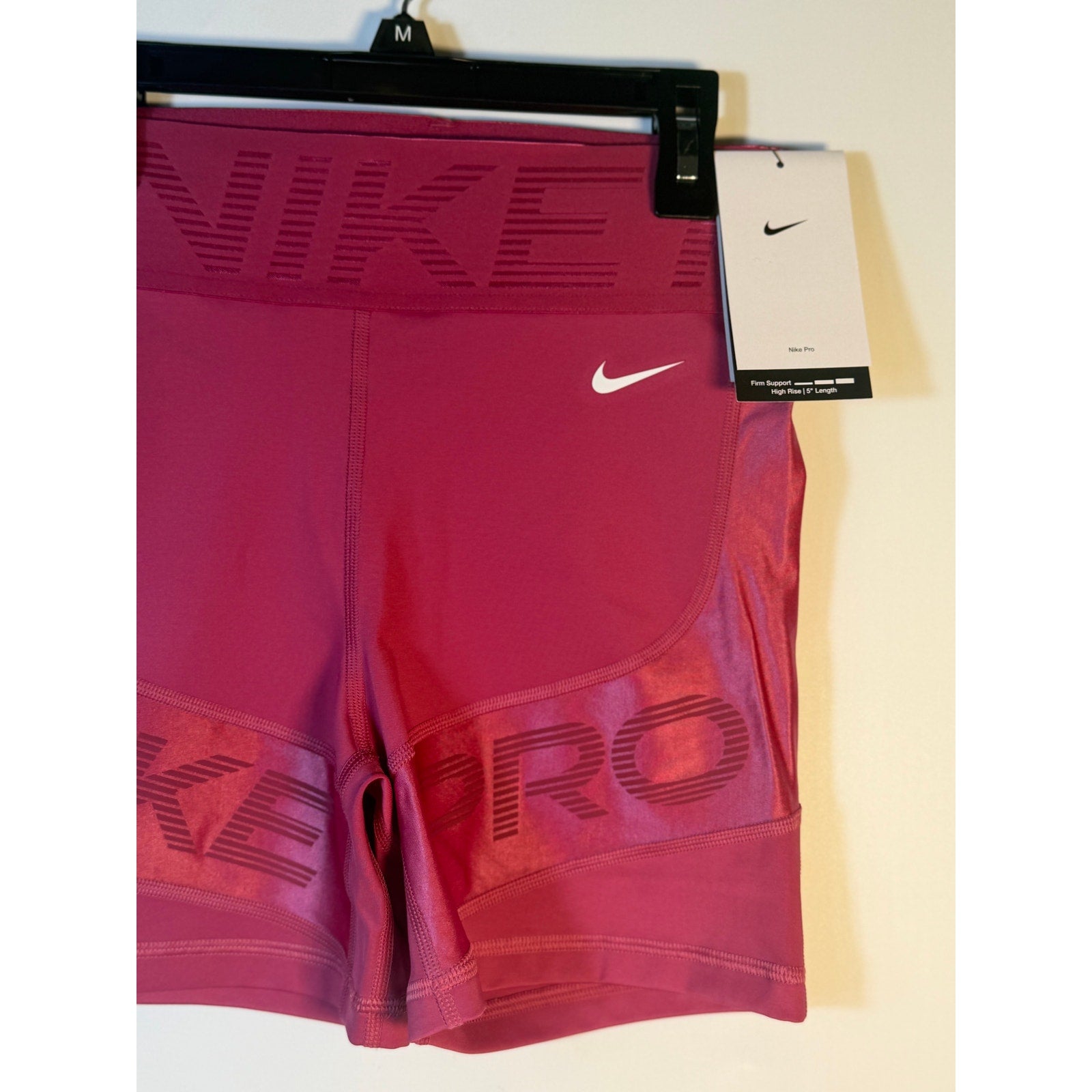 Nike Pro high-rise training shorts for women in berry color, medium size with firm support, shown on a mannequin.