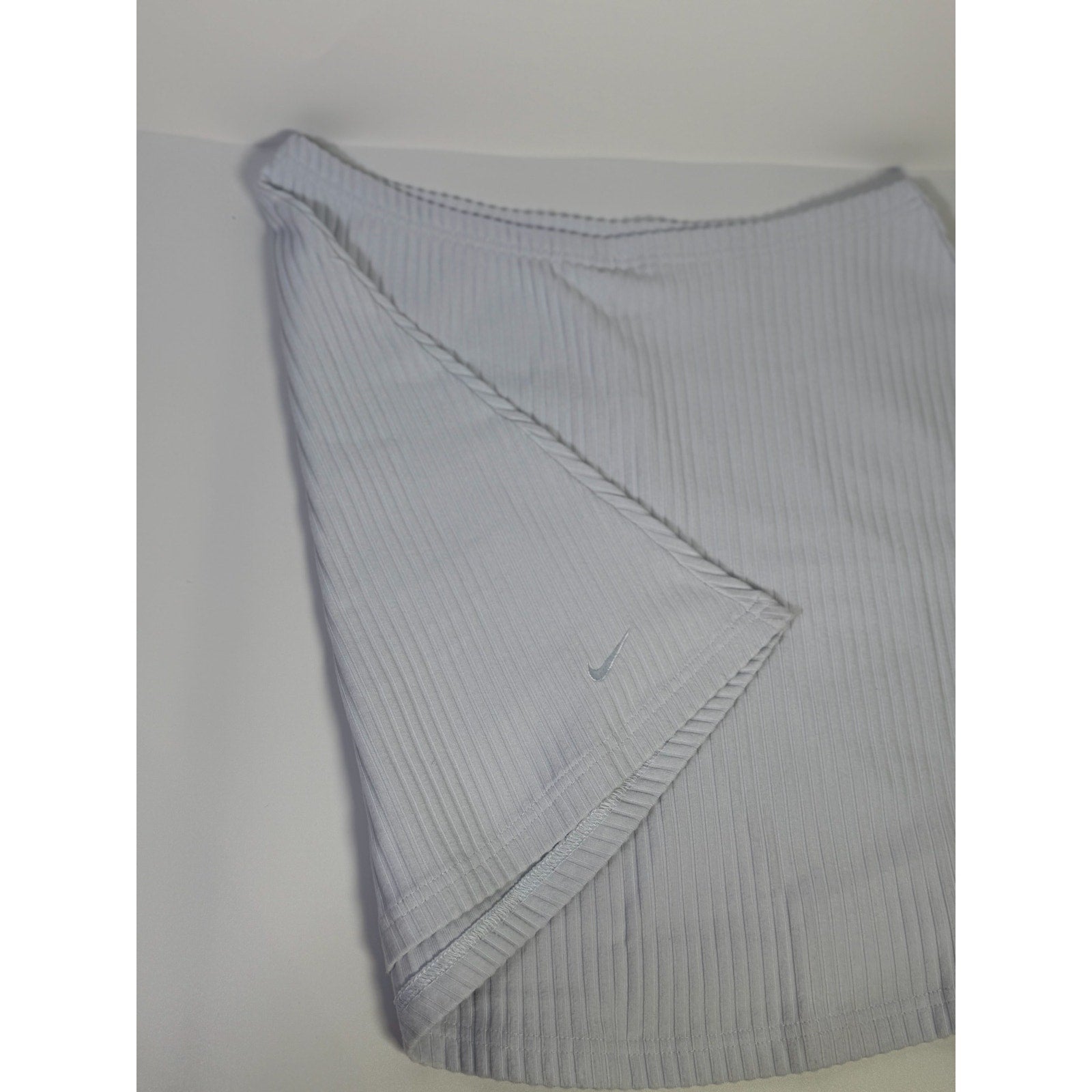 Nike women's ribbed mini skirt in sapphire mist color, size M, featuring a fitted design and stylish ribbed texture.