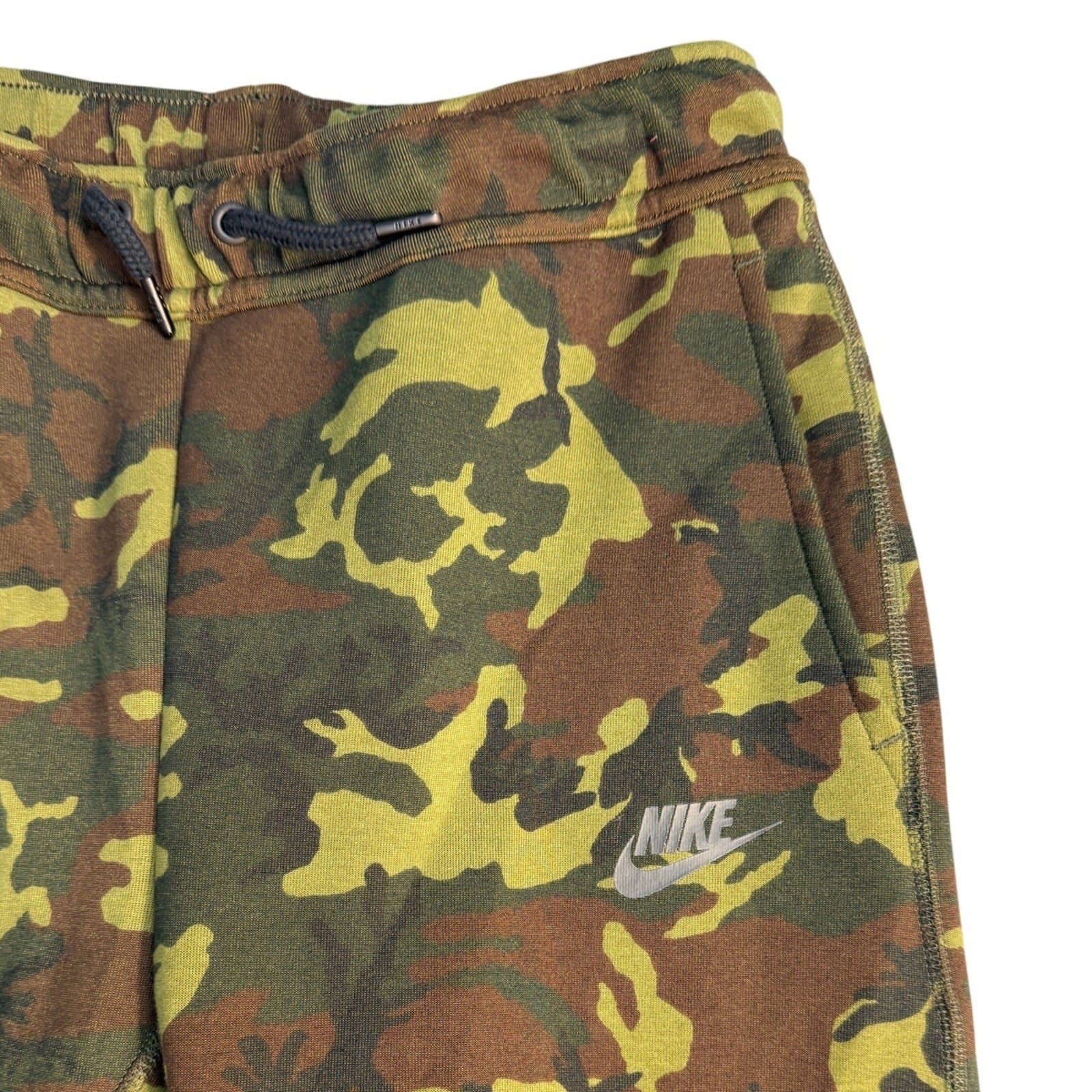 Nike Sportswear Tech Camo joggers for youth, size medium, showing camouflage pattern and comfortable fit in a casual pant style.