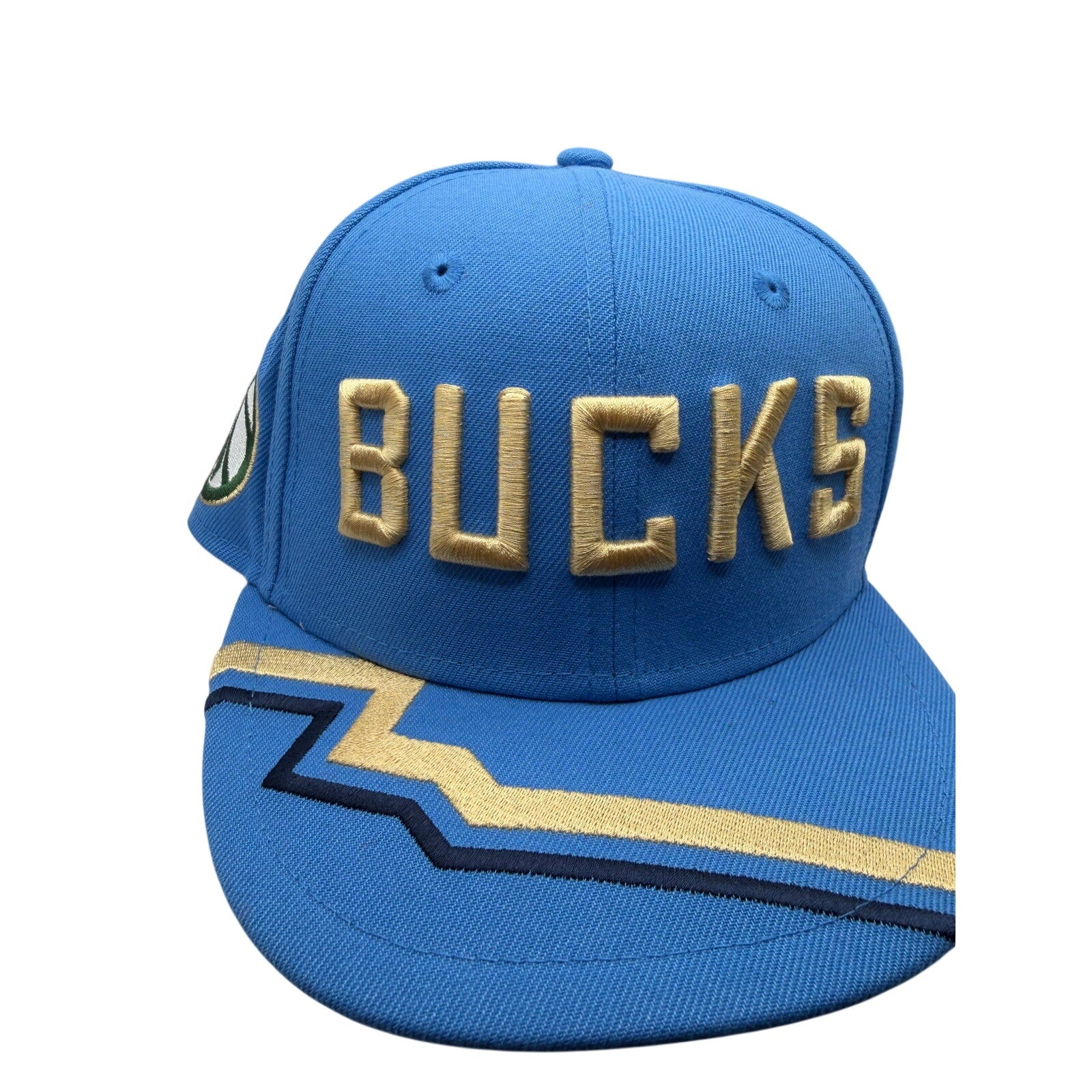 Milwaukee Bucks NBA New Era 9FIFTY snapback hat in blue and gold, featuring team logo and adjustable strap.