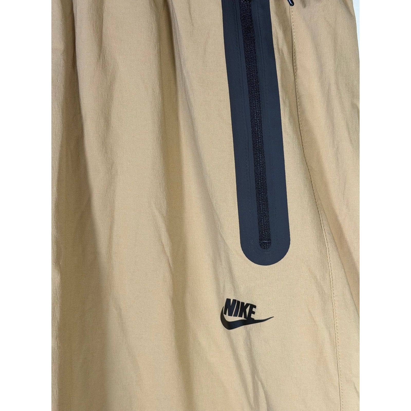 Nike Tech Men’s woven oversized parachute beige pants, size L, with relaxed fit and adjustable waistband.