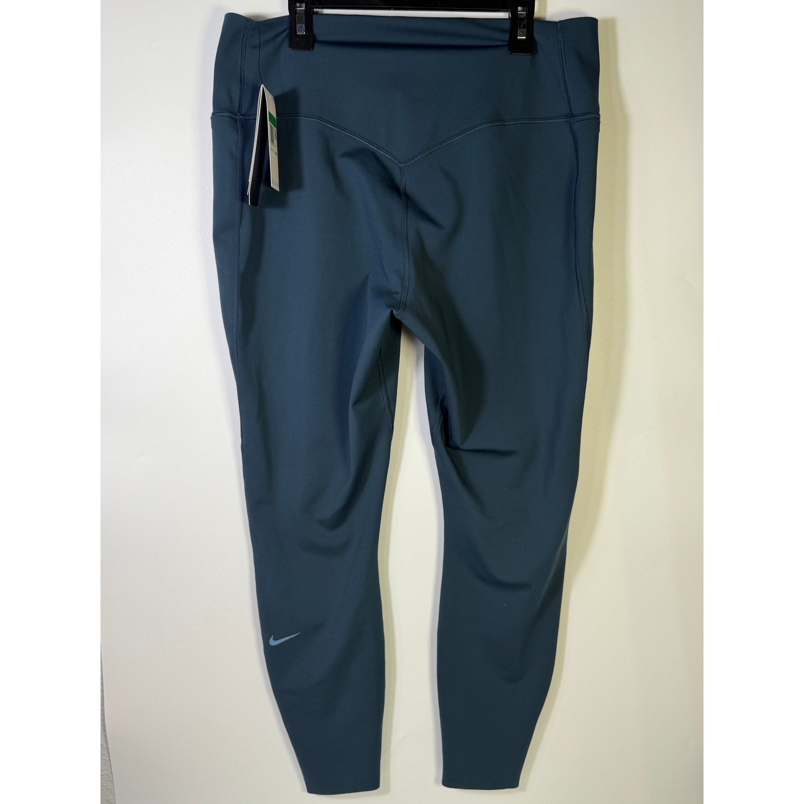 Nike women's blue high-waisted training leggings, XL size, showing close-up of stretchy fabric and comfortable fit.