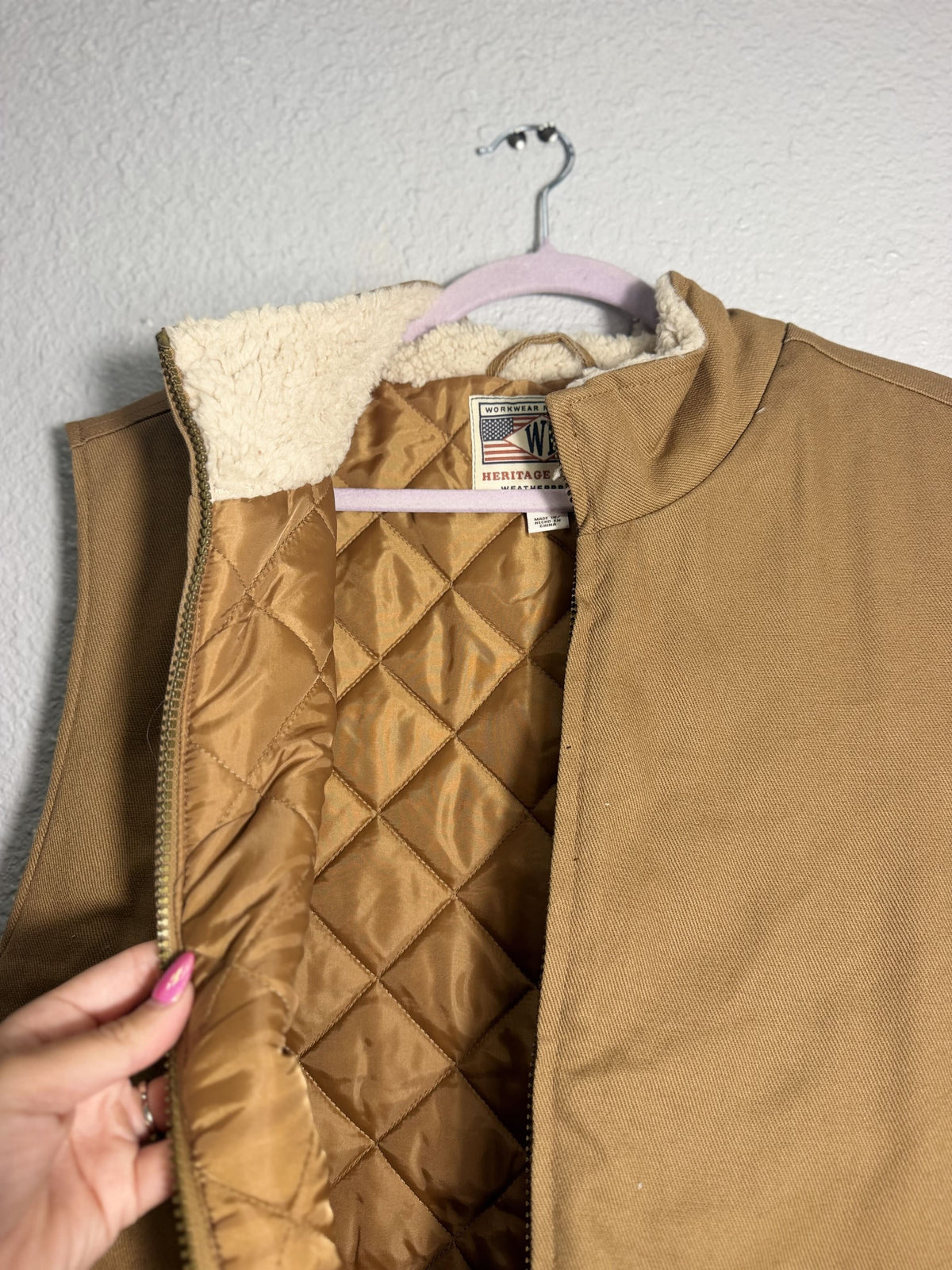 Weatherproof men's tan canvas work vest with Sherpa lining, weatherproof jacket designed for durability and warmth.