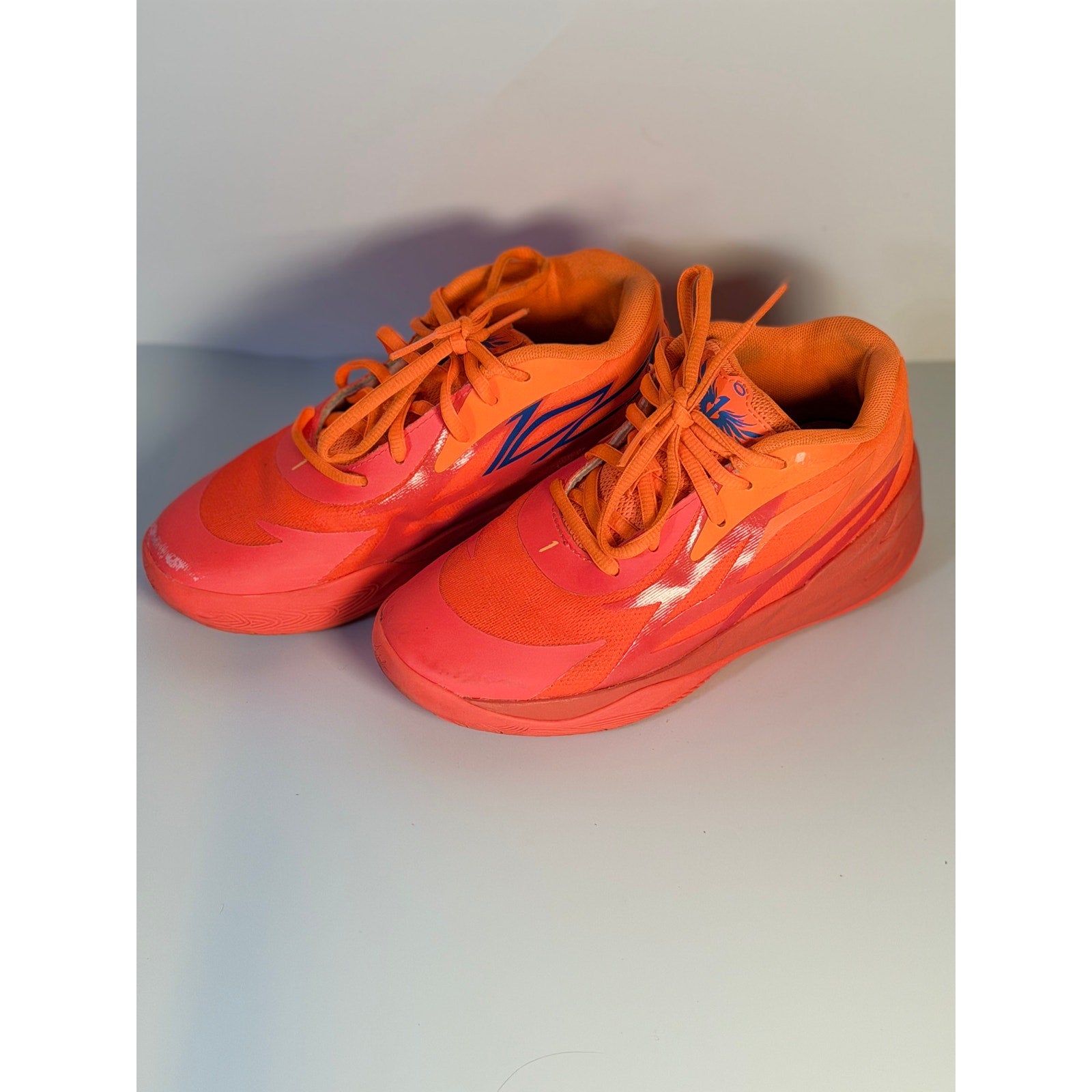 Orange and pink PUMA MB.02 Lo basketball shoes for men, size 5.5, featuring athletic sneaker design with breathable material.
