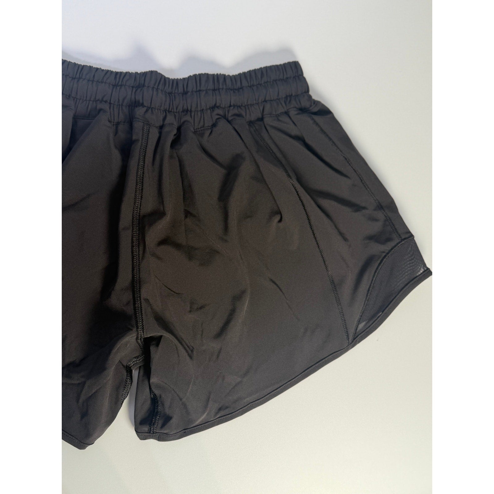 Lululemon Hotty Hot low rise lined shorts in black, size 4, women's athletic shorts with a 4-inch inseam, laid flat.