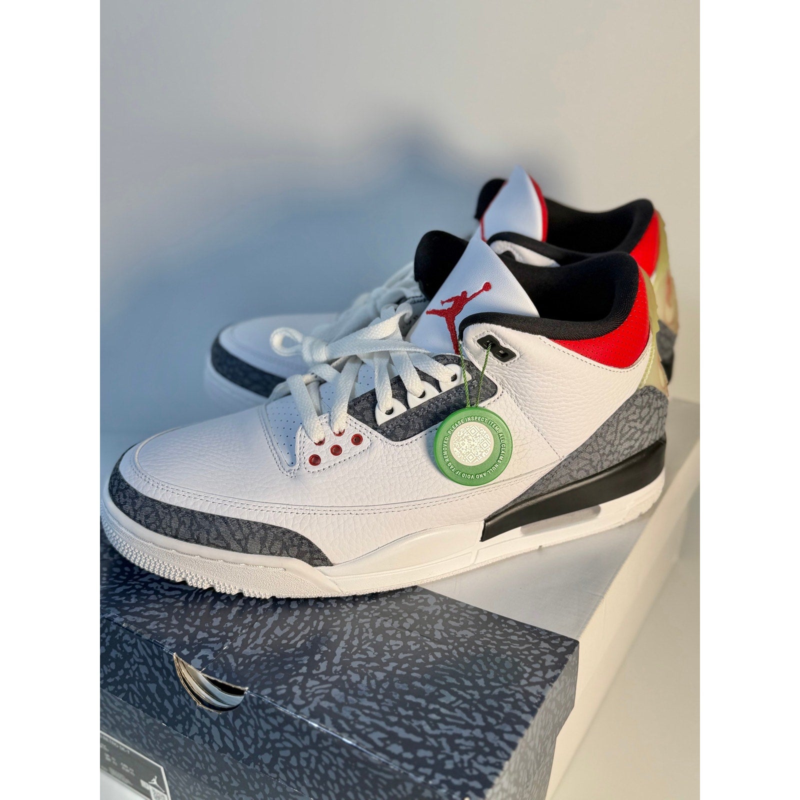 White and gray Air Jordan 3 Retro sneakers with cement details, black accents, and a classic basketball shoe design for men.