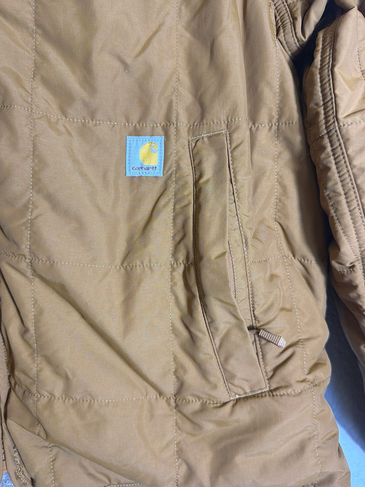 Carhartt women's brown Rain Defender loose fit quilted sherpa-lined jacket, size large, showing front view with quilted interior.
