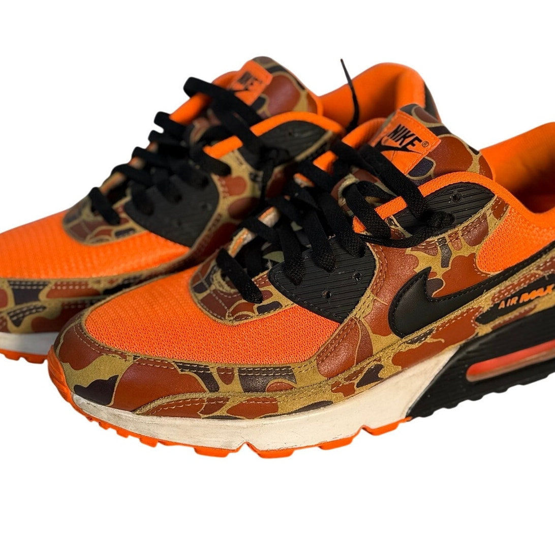 Nike Air Max 90 sneakers in orange camouflage and black, men's size 11, featuring a sleek design and visible Air Max cushioning.