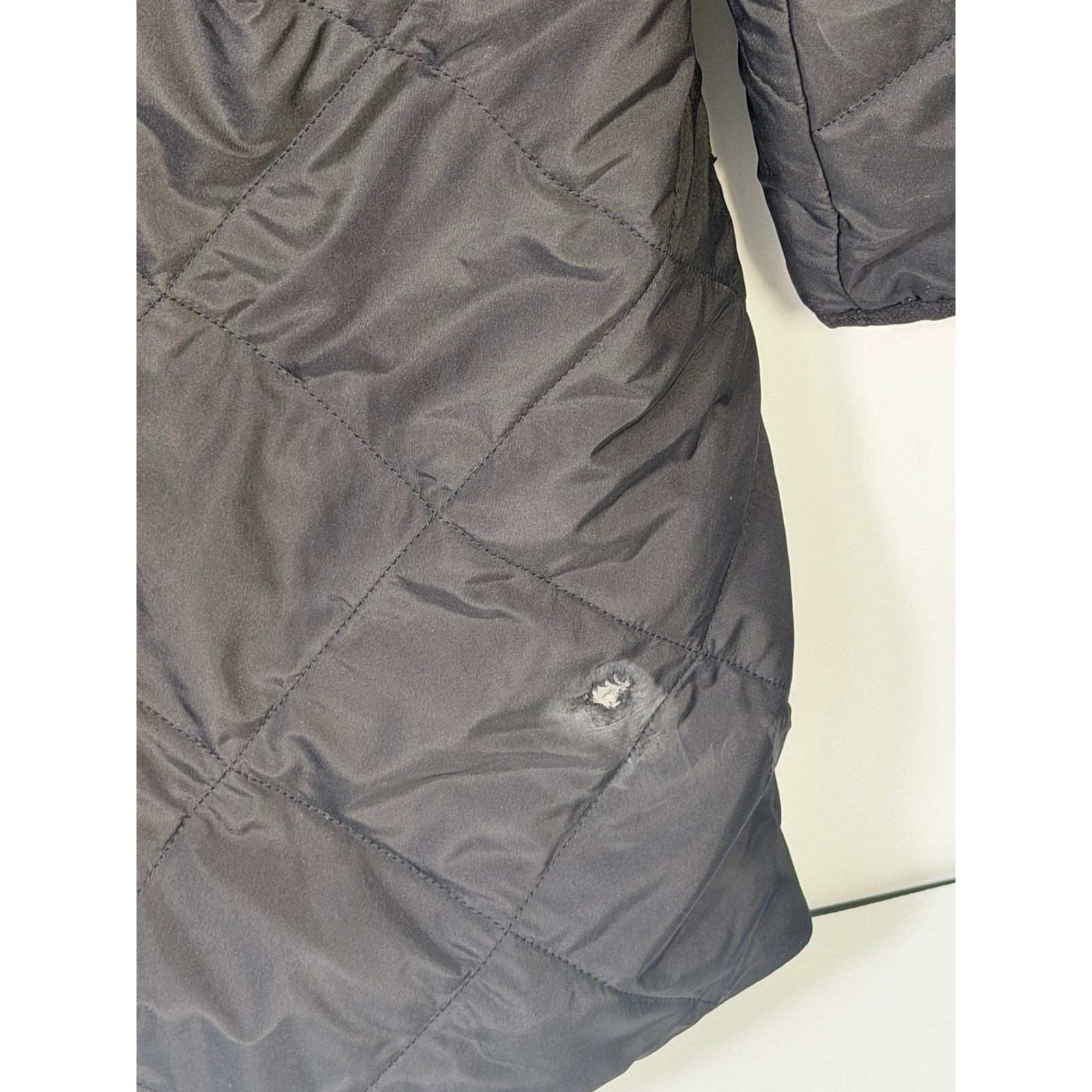 The North Face Women’s Shady Glade insulated parka in black, size XL, shown on a hanger with a hood and quilted design.