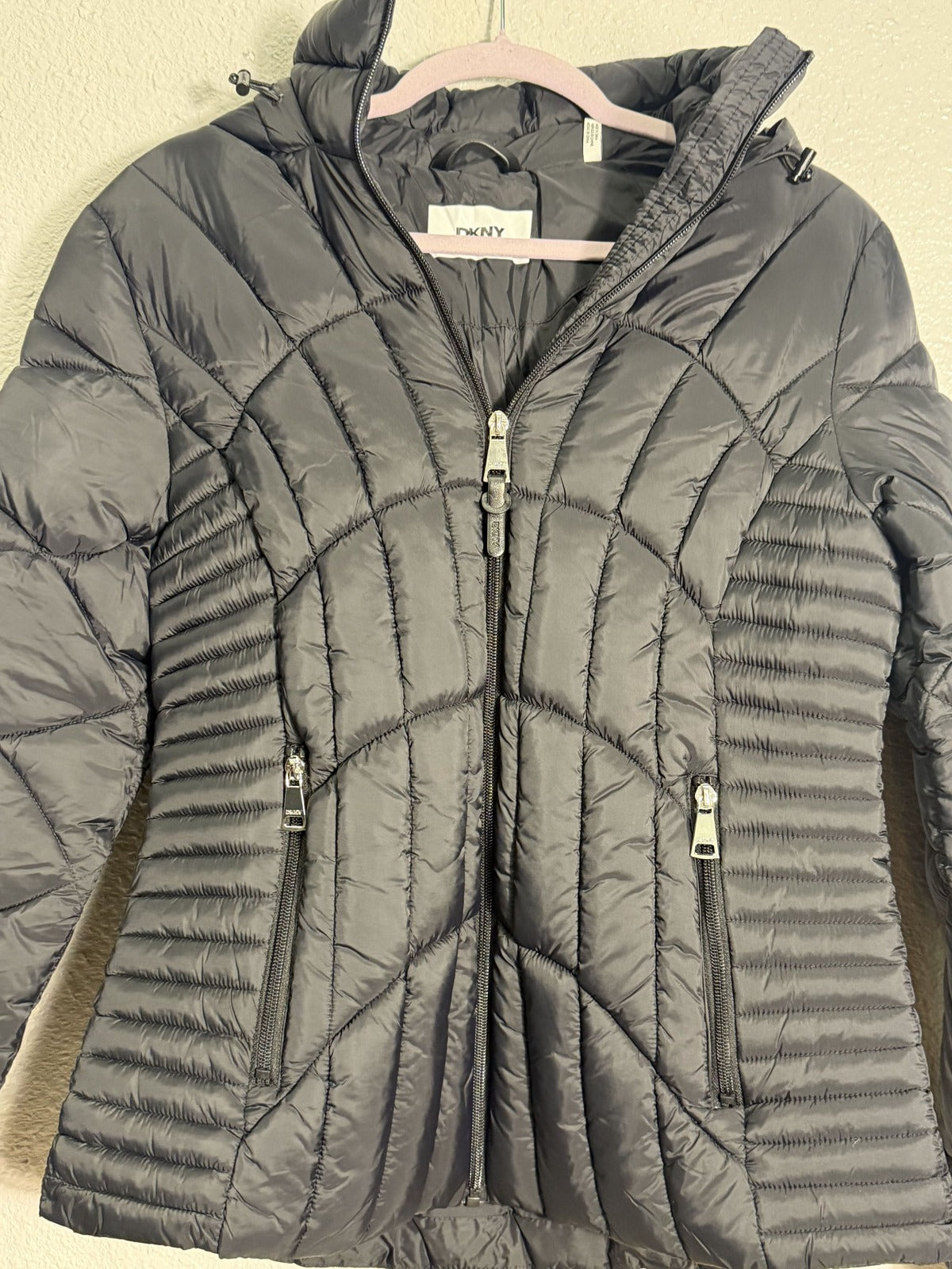 Black DKNY women's hooded quilted puffer jacket, lightweight and insulated with a hood, size small, new with tags.