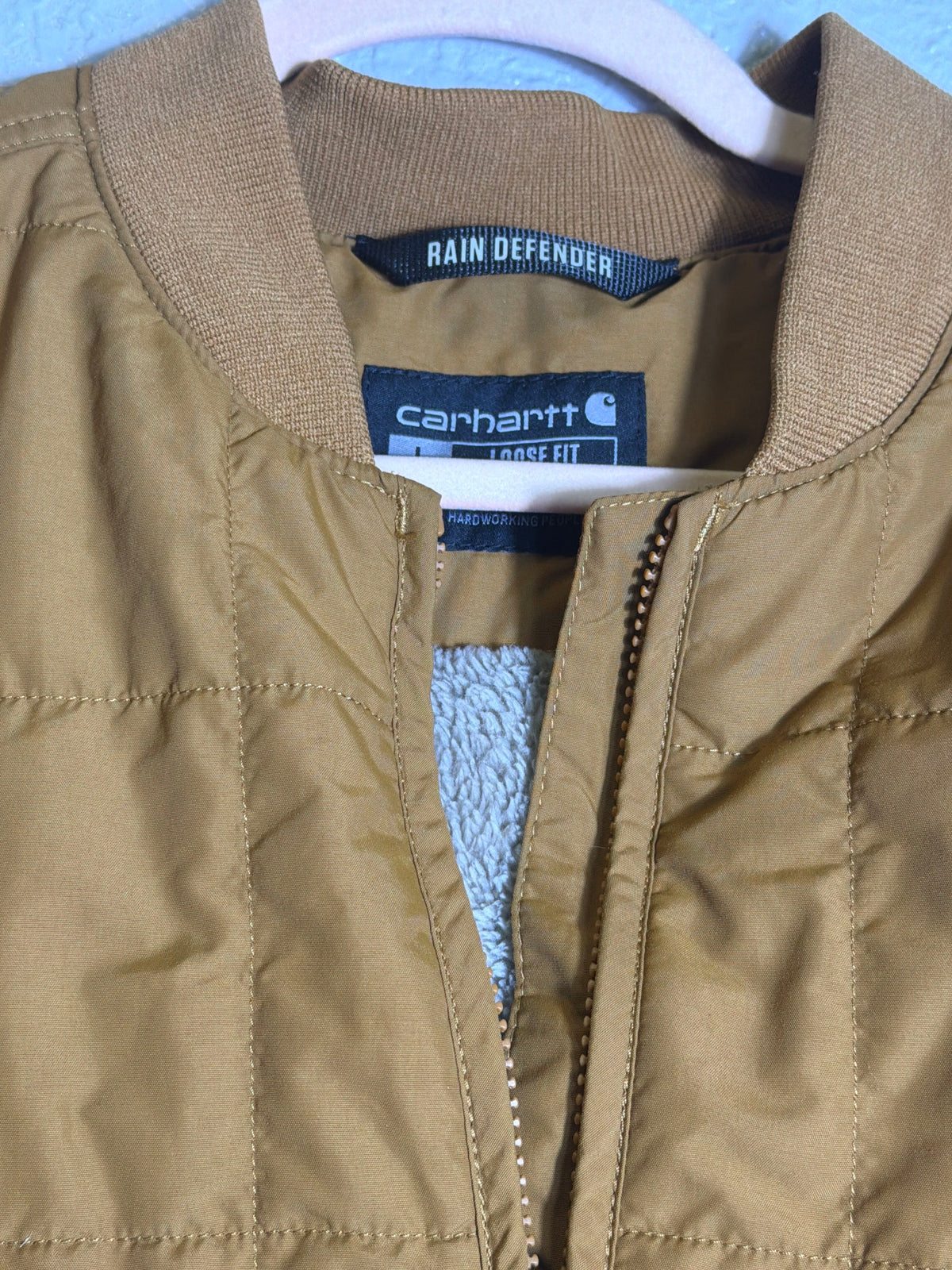 Carhartt Rain Defender loose fit quilted Sherpa-lined women's jacket in brown, size L, showing front view with quilted interior.
