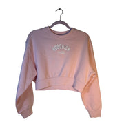 Hoodrich pink cropped sweatshirt for women with rhinestone logo, crewneck style, short length, and long sleeves.