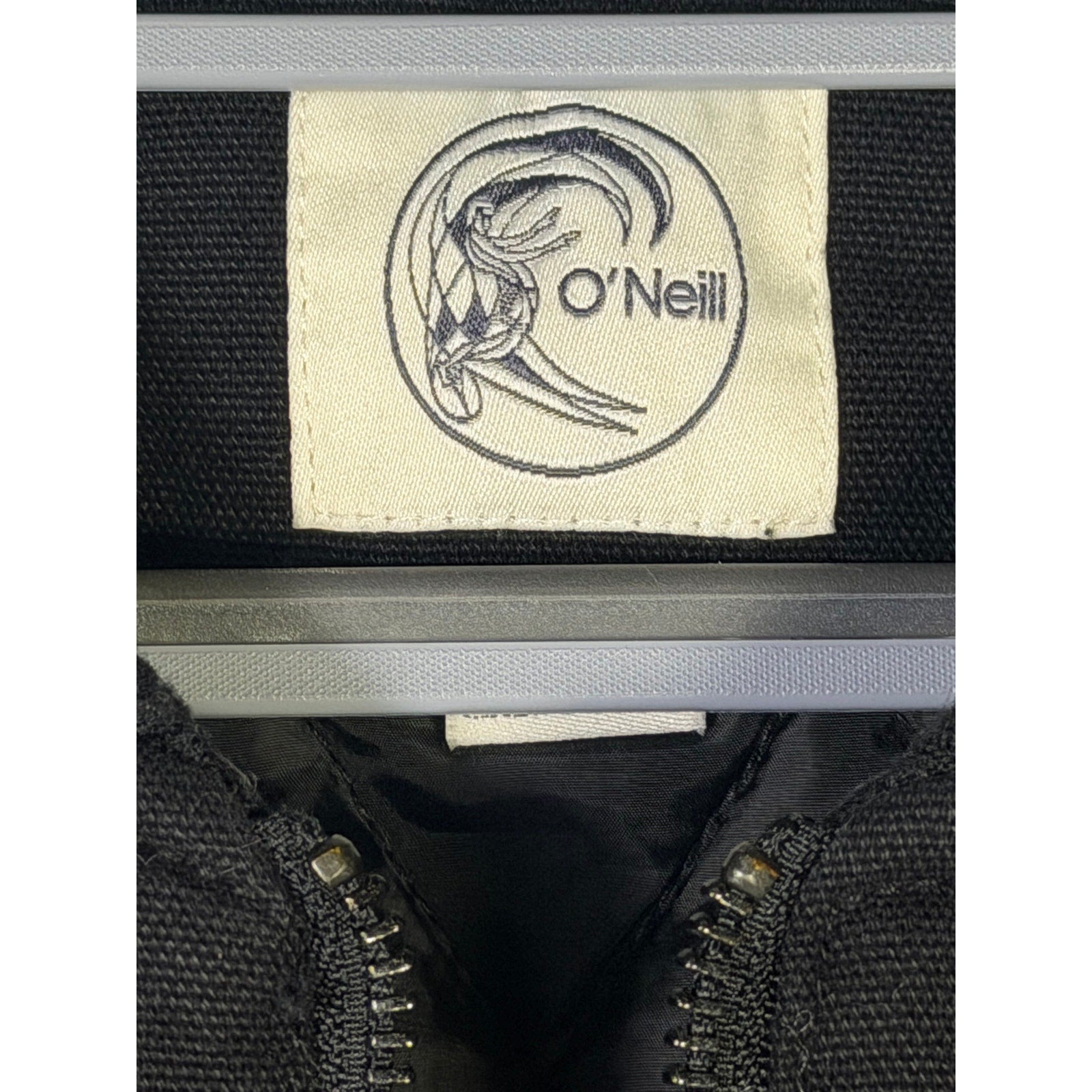O'Neill men's OG Turner vest in black, full zip front, size large, displayed on a hanger with a focus on the vest's front view.