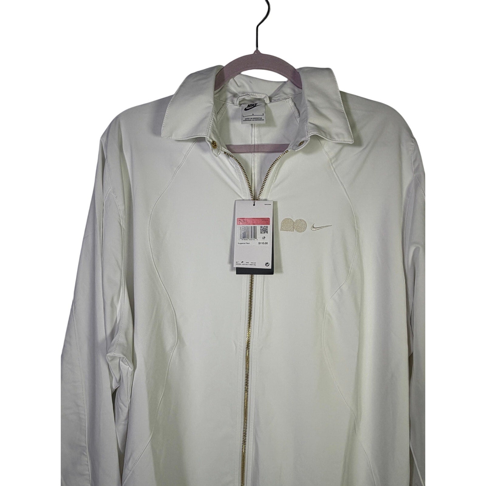 Nike women’s long full zip jacket in cream, size XL, featuring the Nike logo on the front, shown on a hanger.