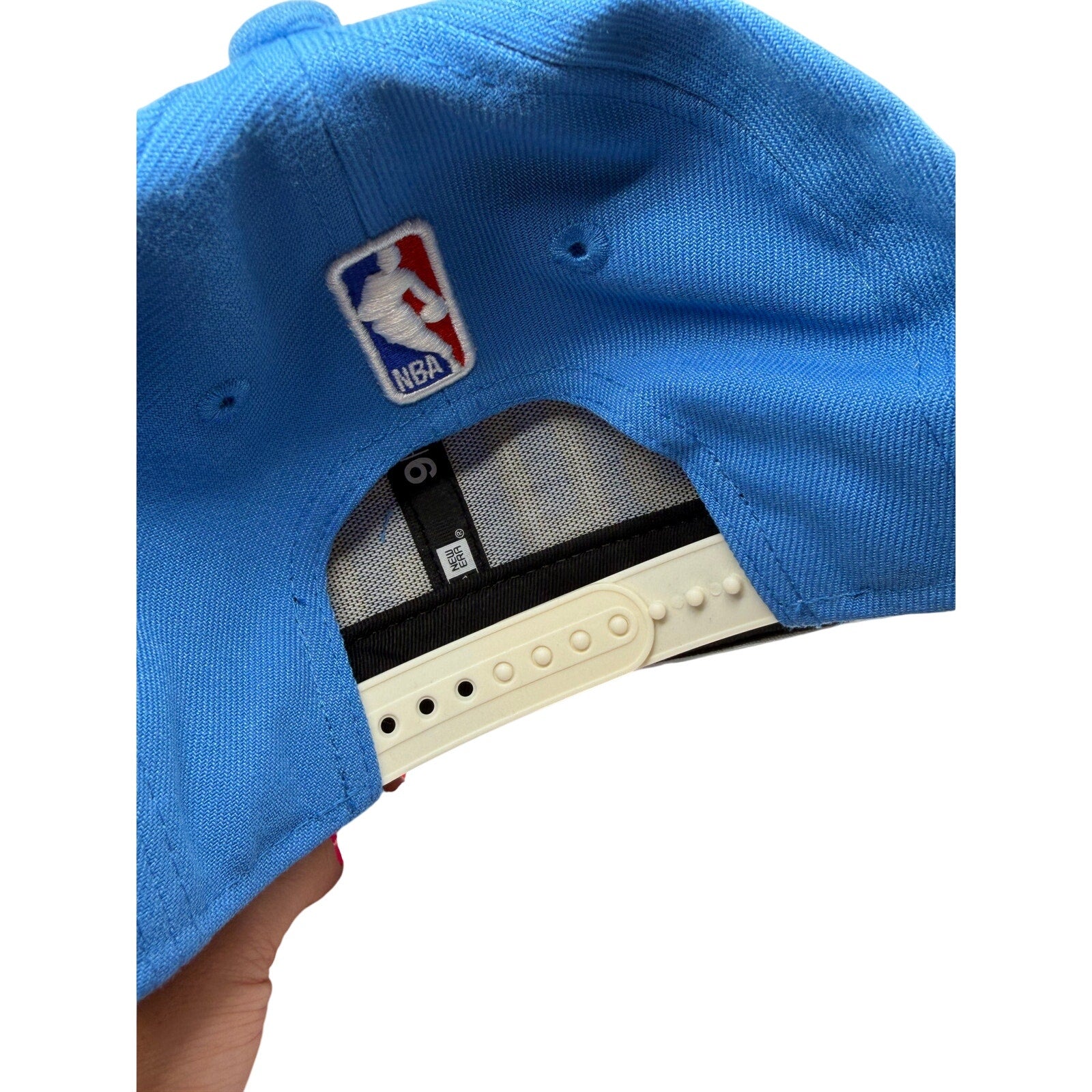 Milwaukee Bucks NBA New Era 9FIFTY snapback hat in blue and gold with adjustable strap, featuring team logo on front.