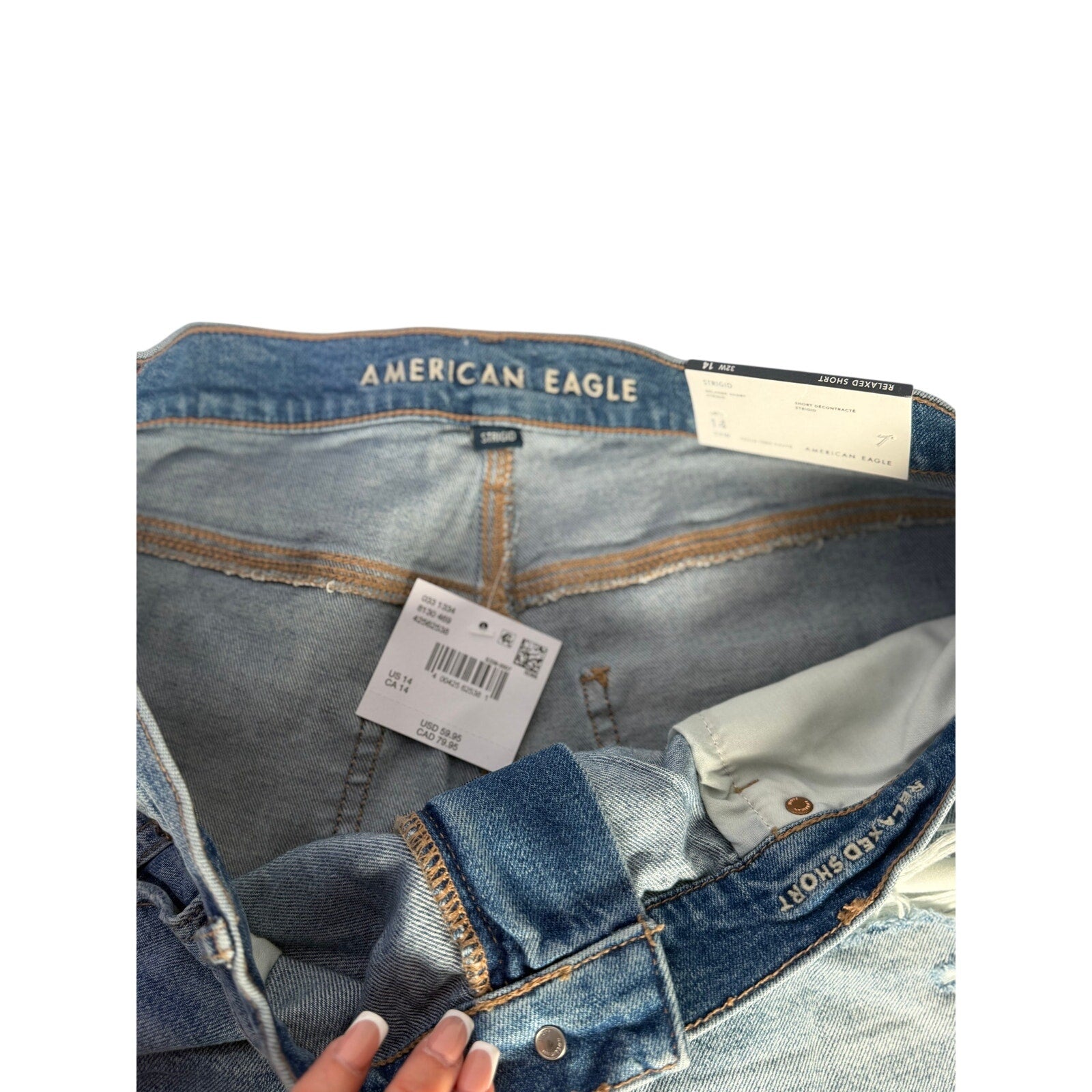 American Eagle women's Strigid relaxed high-rise distressed denim shorts in size 14, showing front view with frayed hem and distressed details.