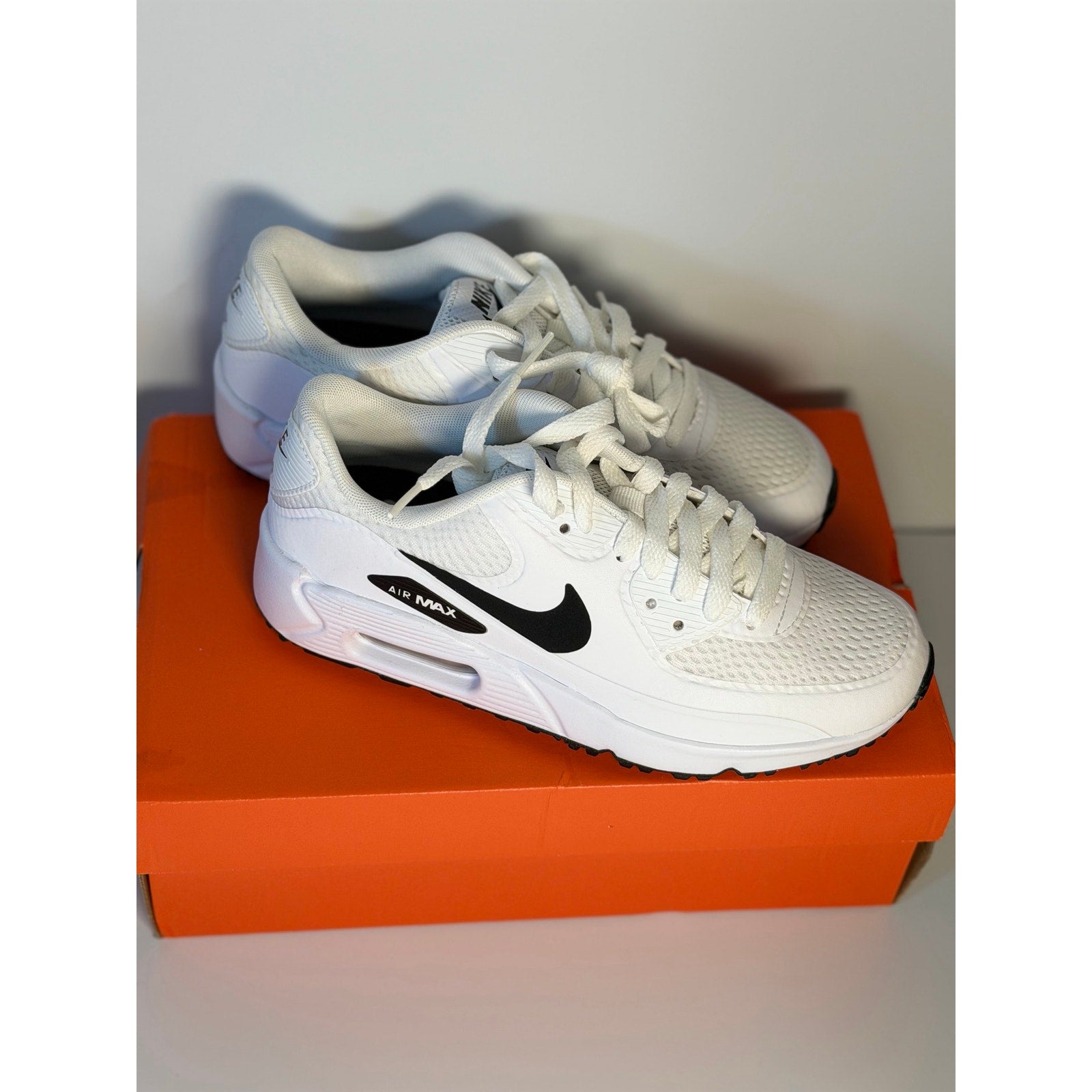 Nike Air Max 90 G golf shoes in white and black for men and women, featuring sporty design and Nike branding.