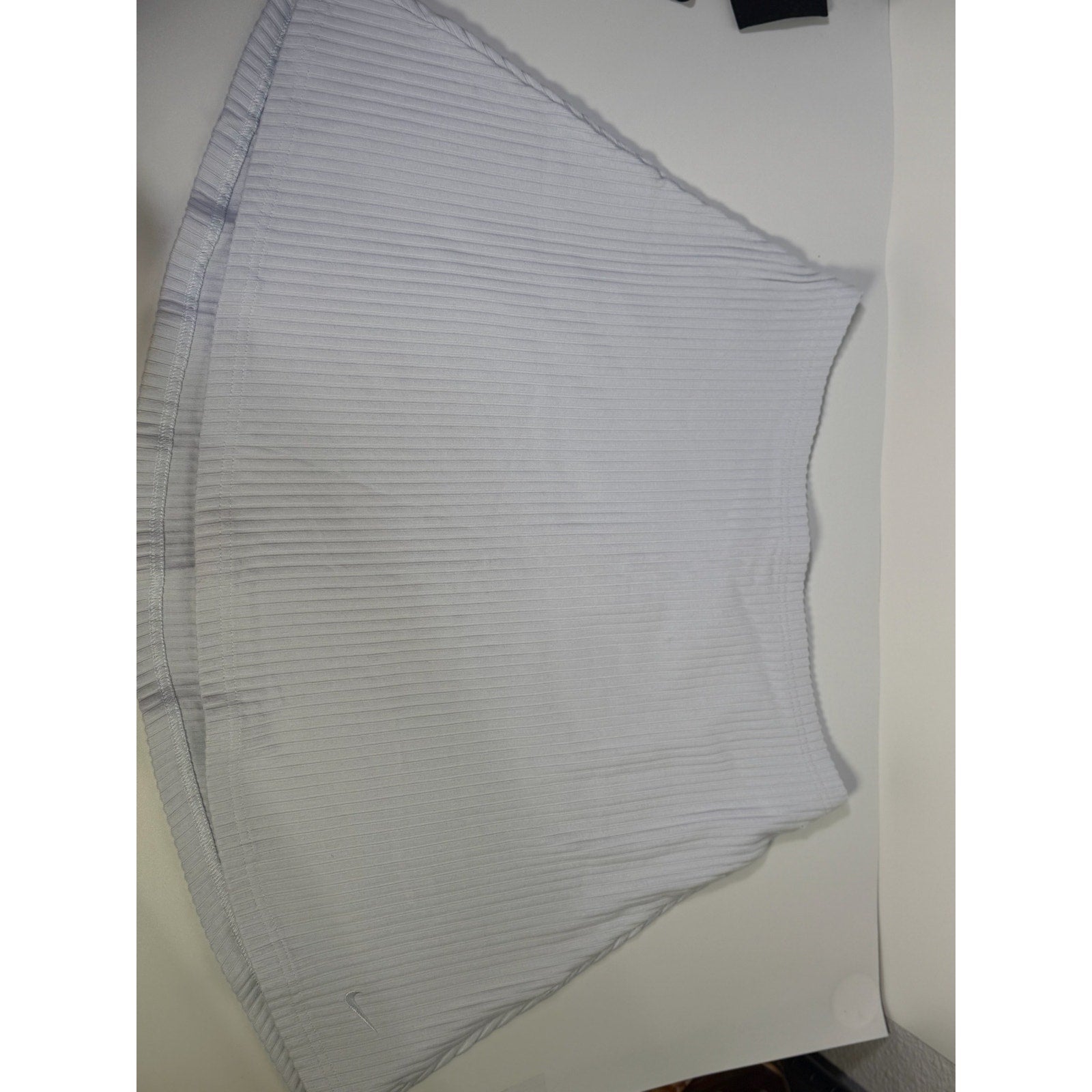 Nike women's ribbed mini skirt in sapphire mist color, size M, featuring a fitted design and soft fabric texture.