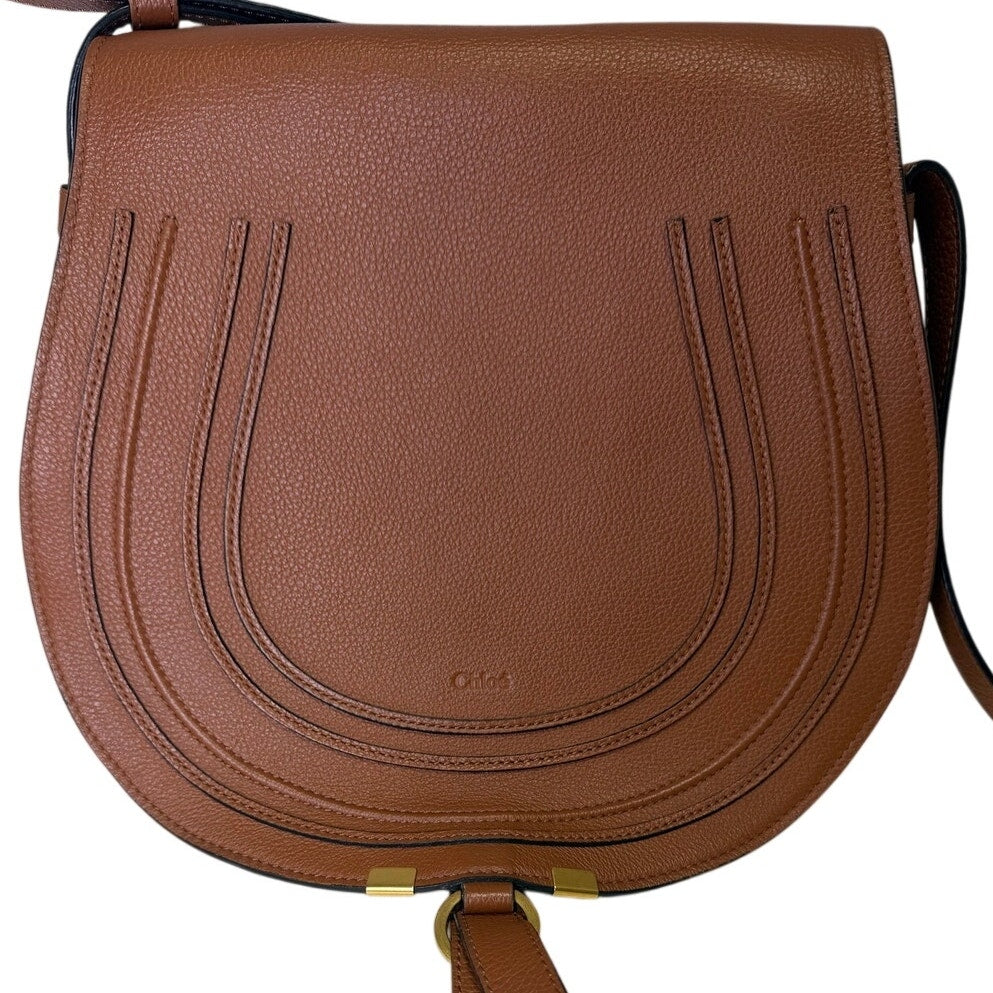 Chloé Marcie medium saddle crossbody handbag in grained calfskin leather with gold hardware, in brown color.