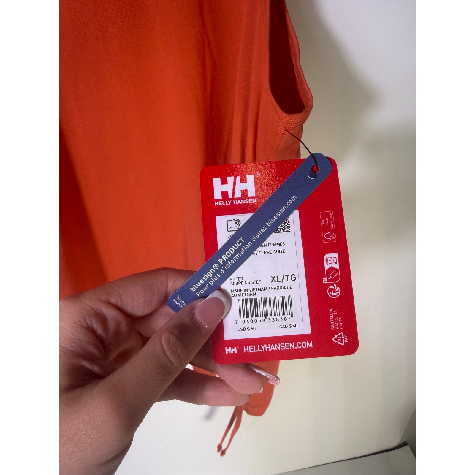 Helly Hansen women's orange active tank top with sleeveless design, drawstring hem, ideal for sports and active wear.