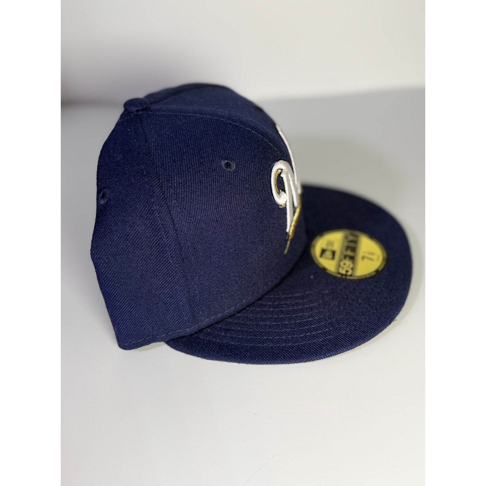 New Era Milwaukee Brewers 59FIFTY fitted cap in blue, size 7 1/8, MLB team logo, structured baseball hat.