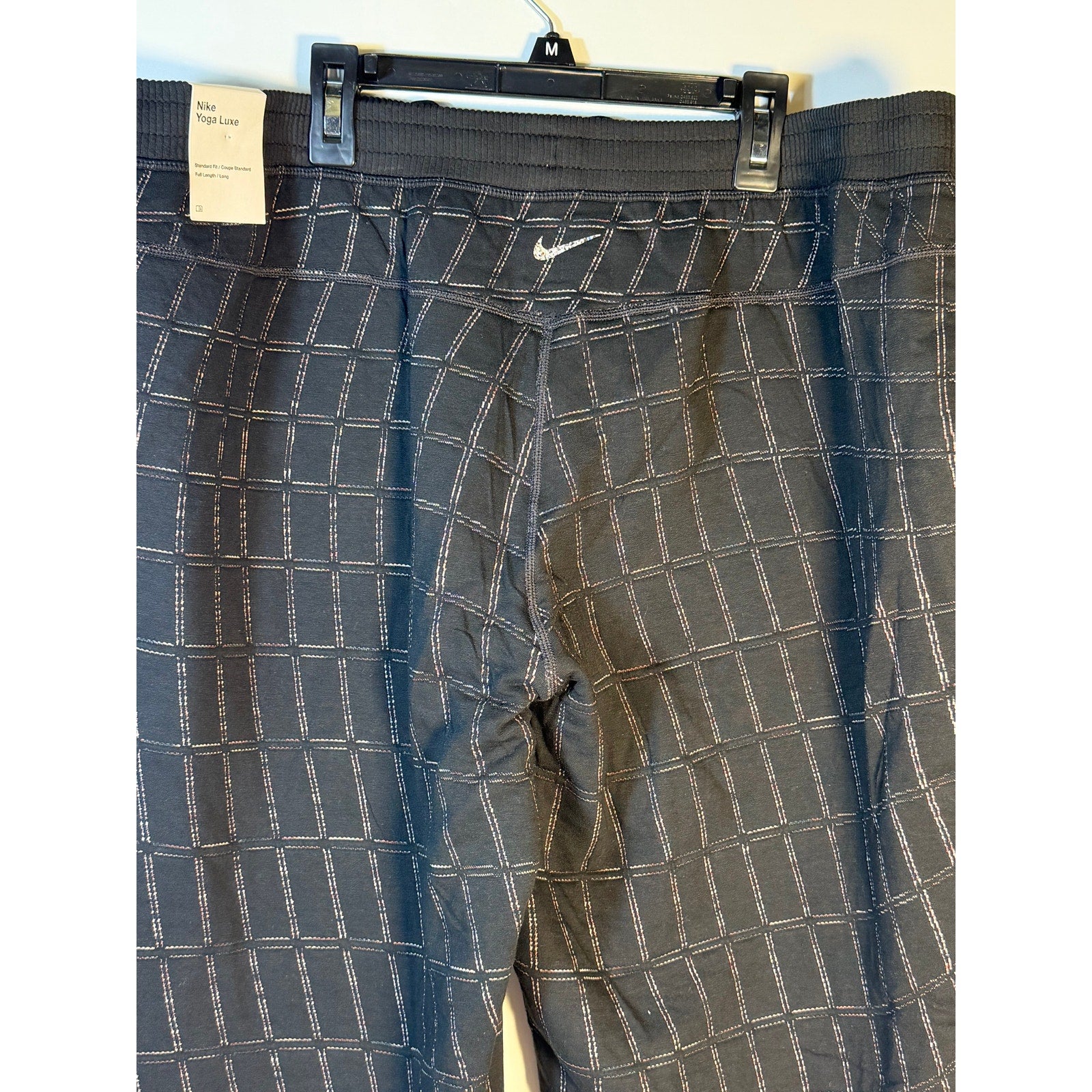 Nike Women's Yoga Luxe Grid Print Jogger Pants in black, casual athletic pants with comfortable fit and stylish design.
