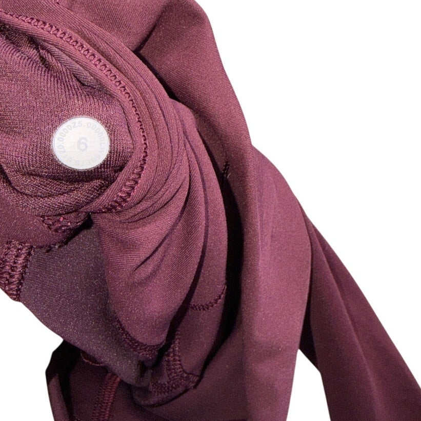 Lululemon women's burgundy high-rise flared yoga leggings size 6, shown laid flat with a fitted waistband and flared legs.