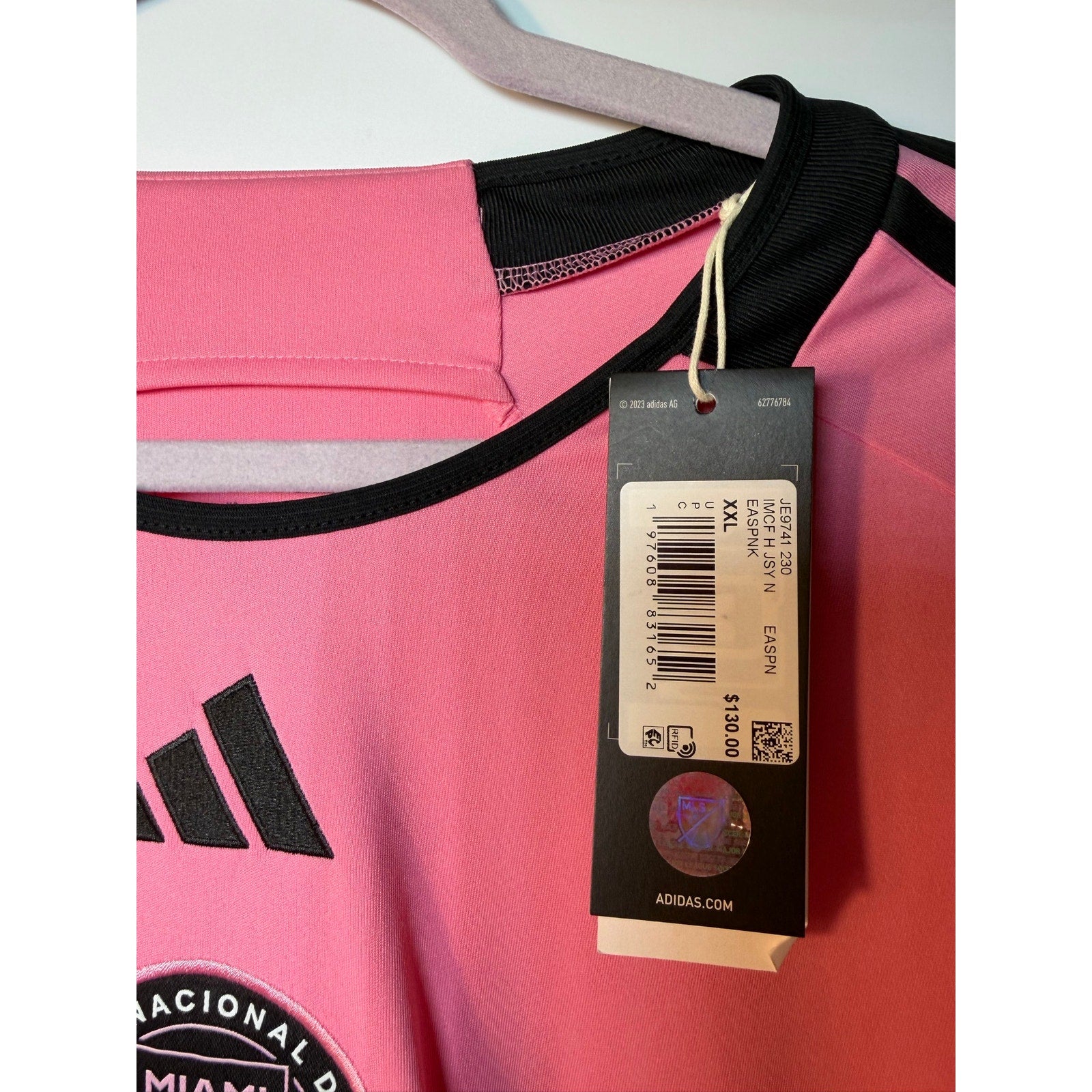 Pink Adidas Inter Miami CF Lionel Messi jersey with team logo and player name, displayed on a hanger.