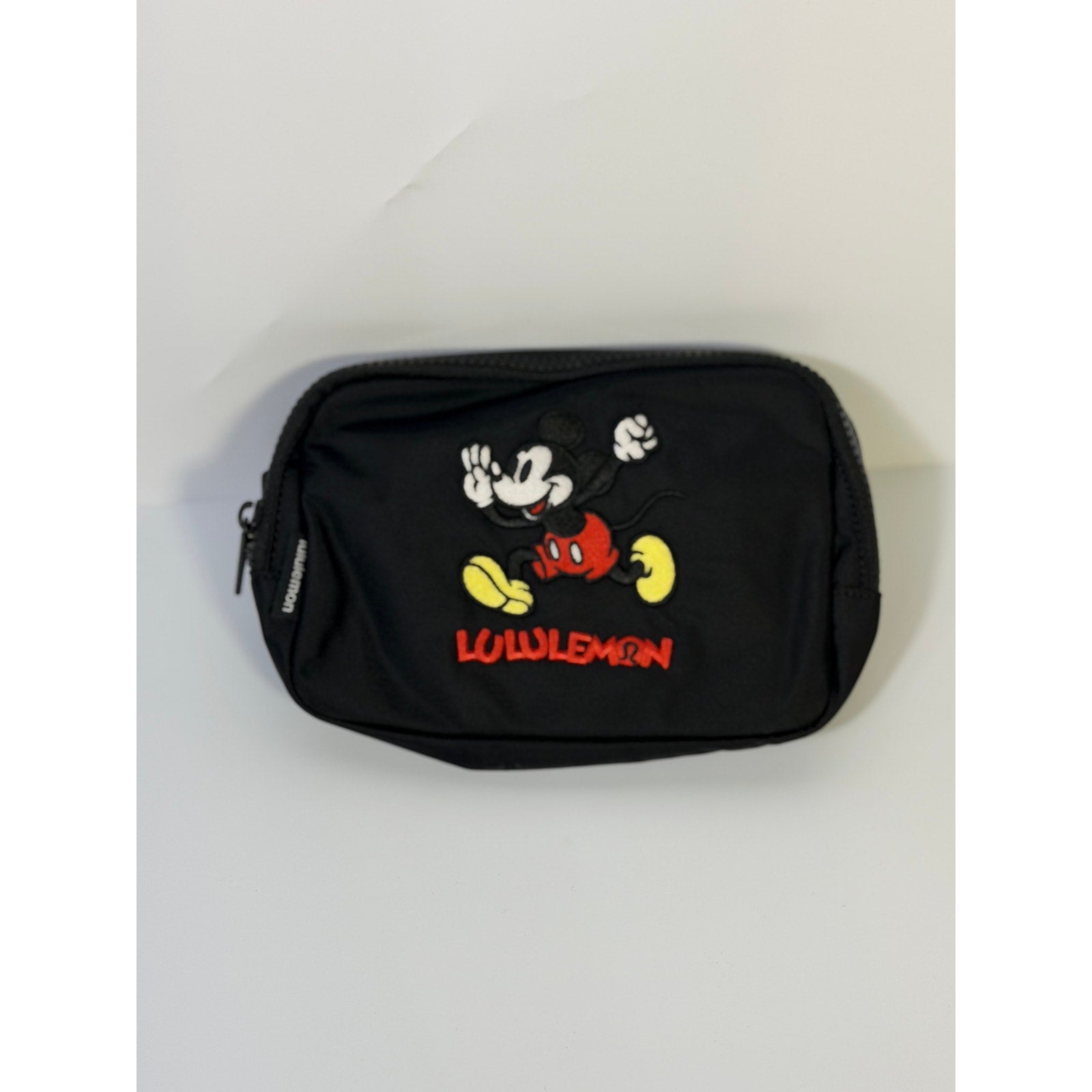 Lululemon Disney Mickey Mouse black embroidered belt bag with adjustable strap and zipper closure, stylish and compact accessory.