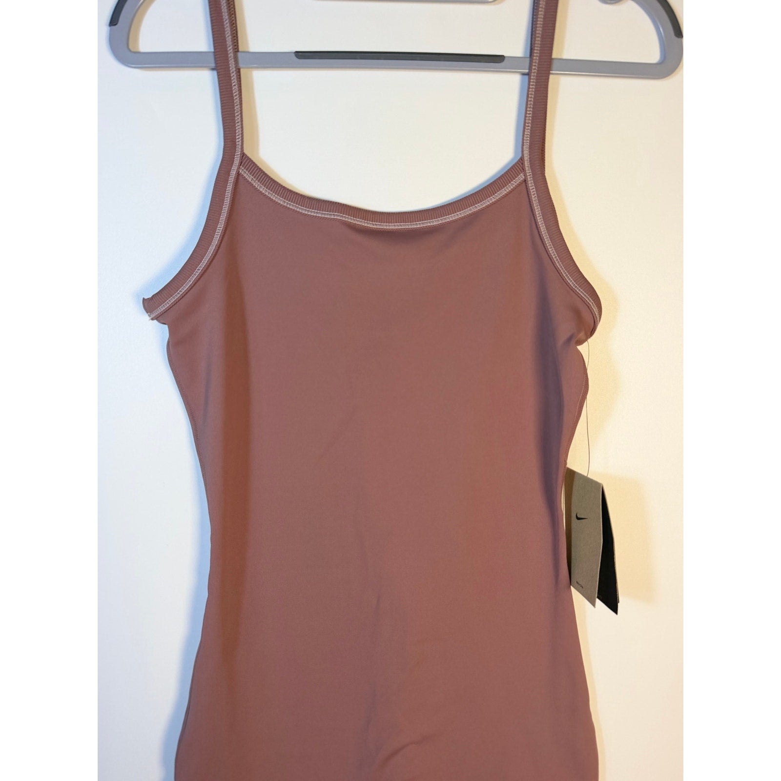 Nike women's mauve training bodysuit romper, size small, fitted one-piece activewear for exercise and casual wear.