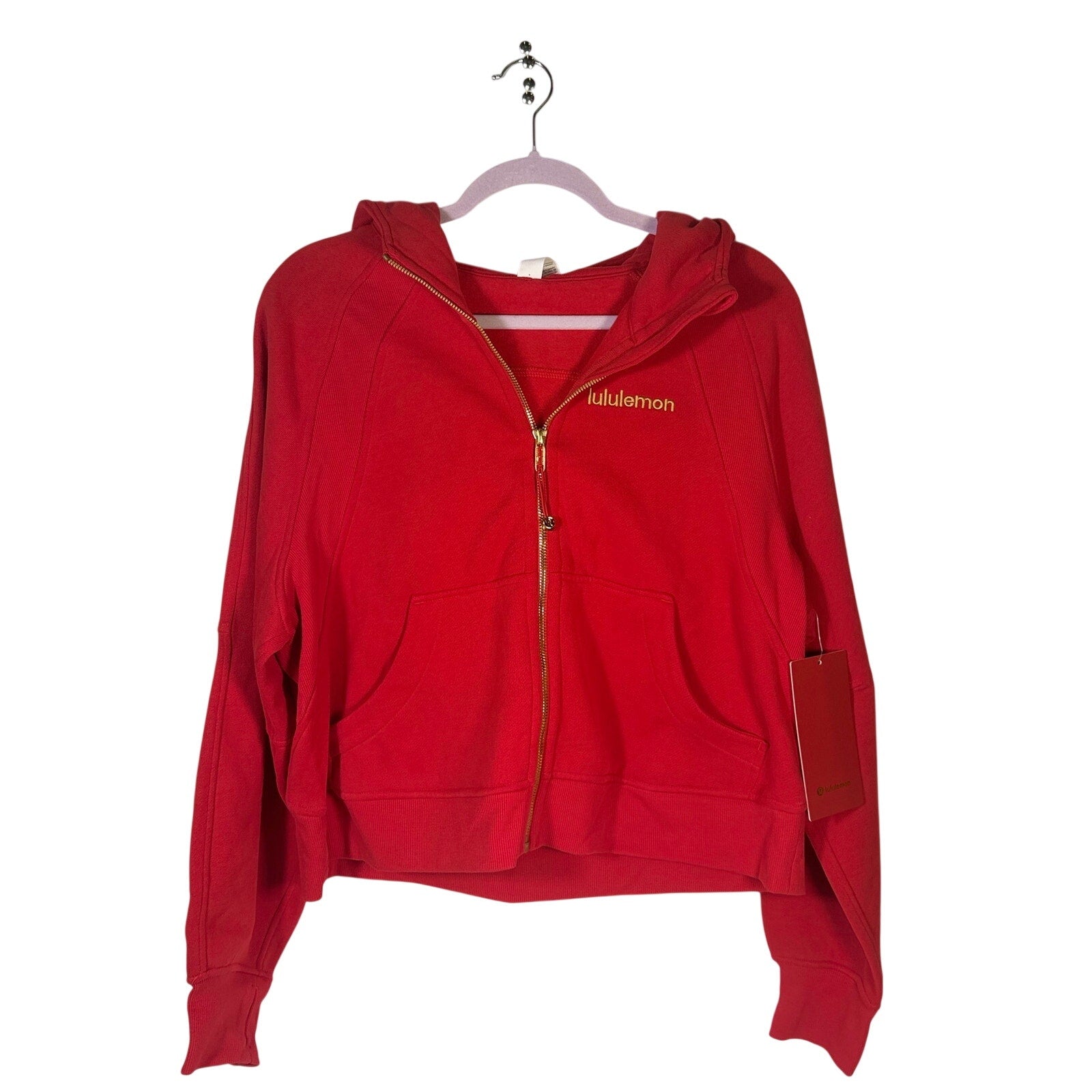 Lululemon women's red scuba oversized full zip hoodie, size M/L, with gold accents, displayed on a hanger.