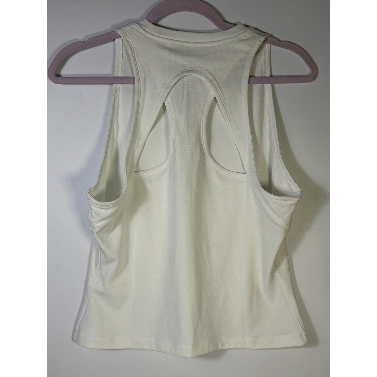 NikeCourt women's Dri-FIT tennis tank top in white, size large, shown on a hanger with a sleeveless design and athletic fit.