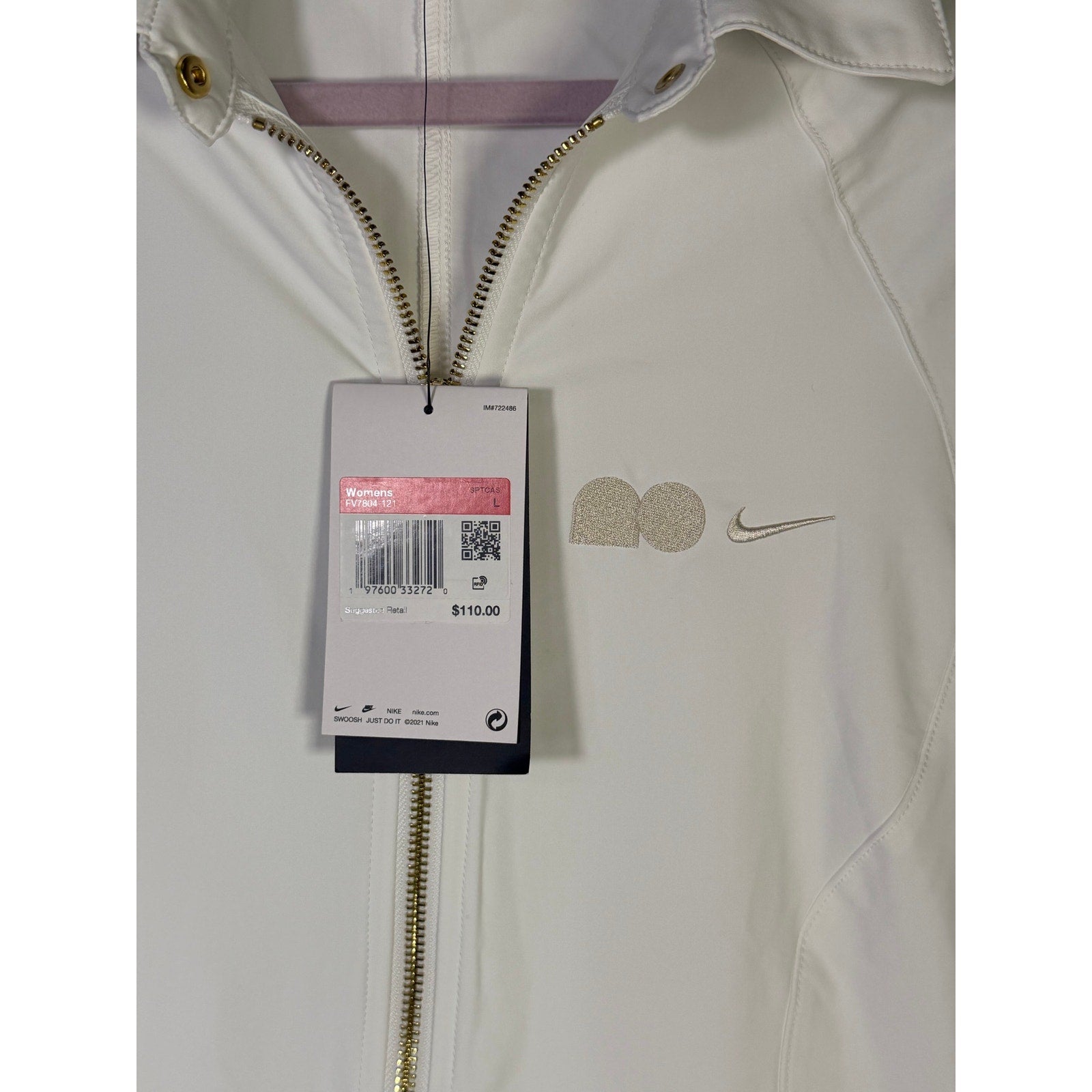Nike women's long full zip jacket in cream, size XL, featuring Nike logo, shown hanging with zipper and long sleeves.