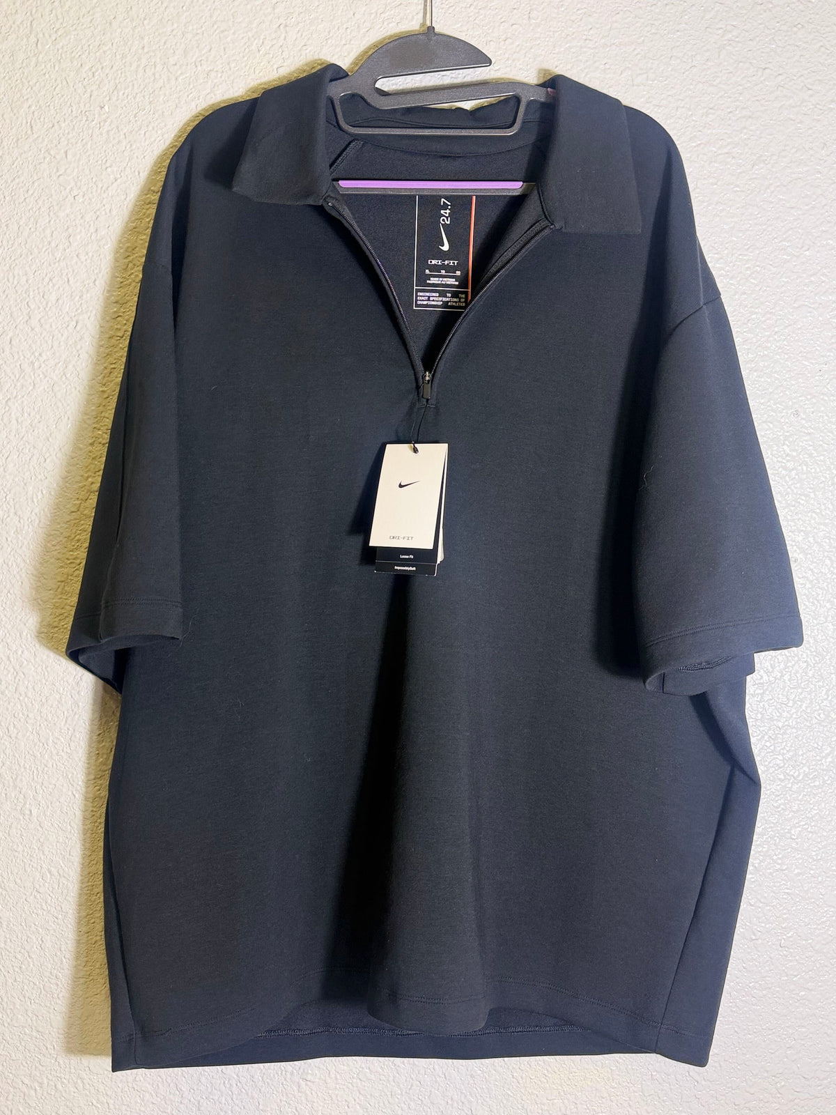 Nike 24.7 ImpossiblySoft men's Dri-FIT black 1/4-zip polo shirt, size XL, with a sleek collar and Nike logo detail.
