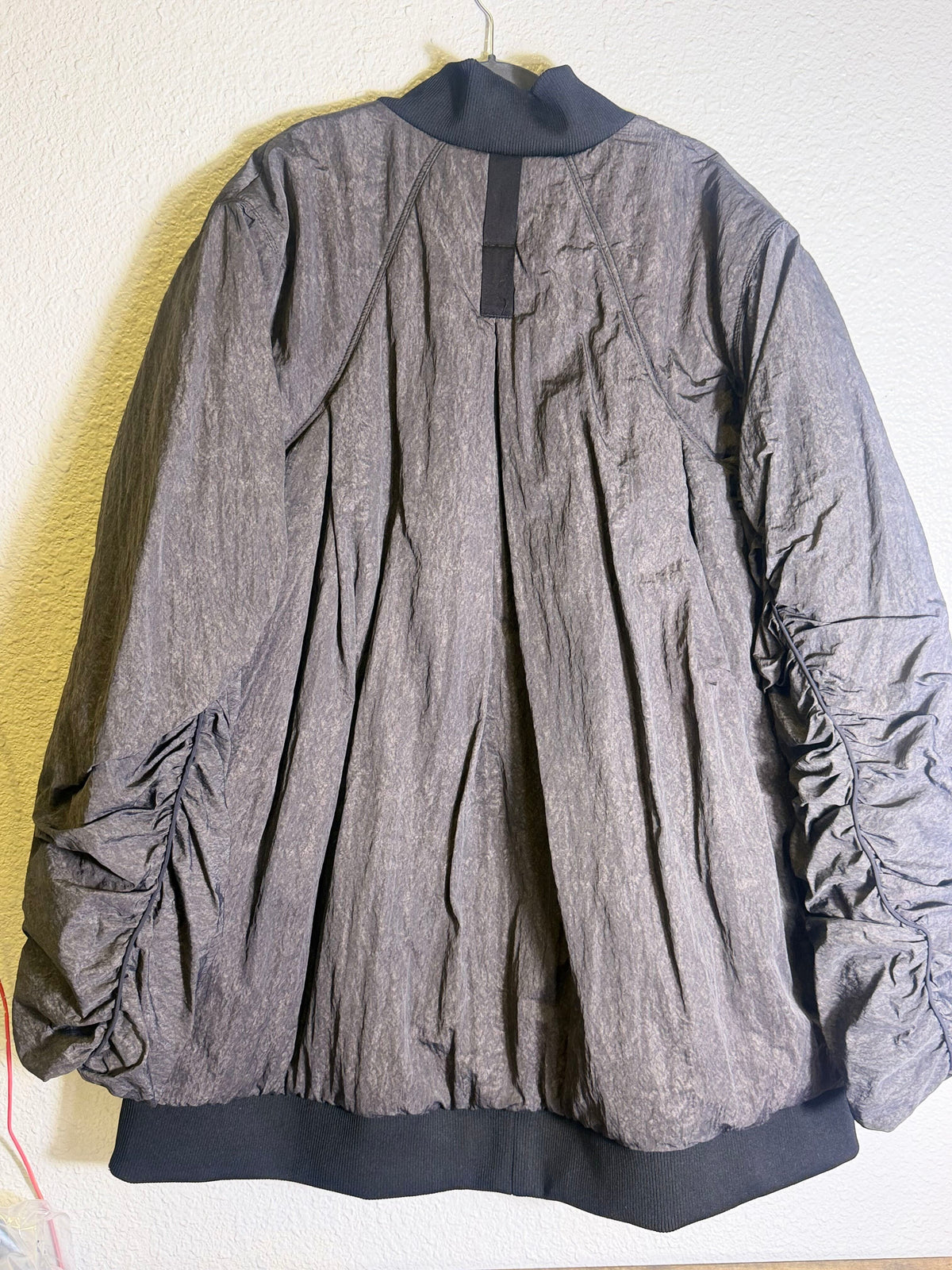 Gray Free People Movement oversized bomber jacket for women, shown on a model, featuring a relaxed fit and stylish design.