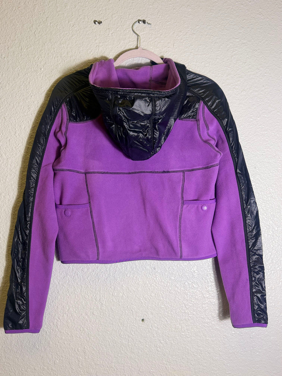 Free People Movement cropped hooded fleece jacket in violet and black, showing a cozy, stylish jacket with a hood and zip closure.
