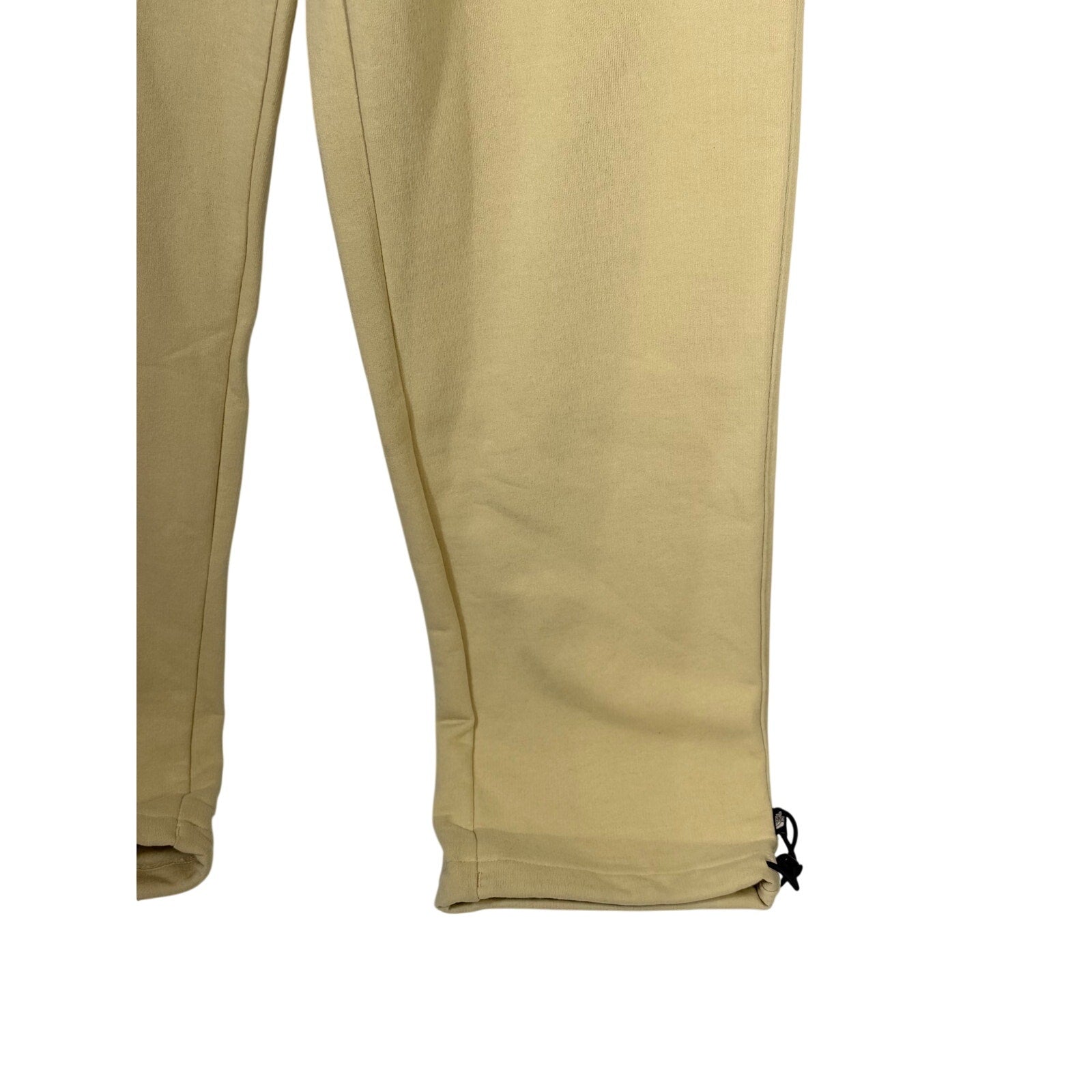 The North Face men's AXYS sweatpants in gravel beige, size small, with a relaxed fit and logo detail, displayed on a plain background.