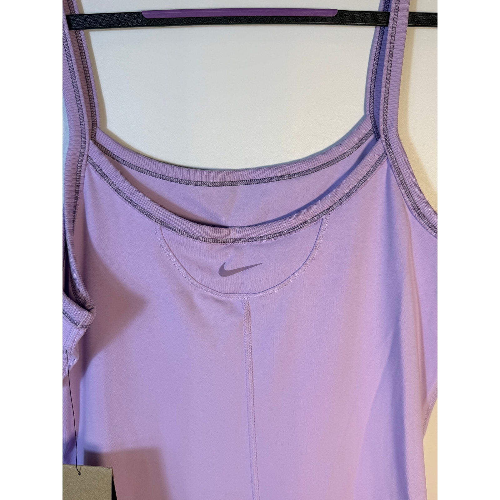 Lavender Nike One Dri-FIT women's training romper bodysuit, front view, showcasing the athletic fit and moisture-wicking fabric.