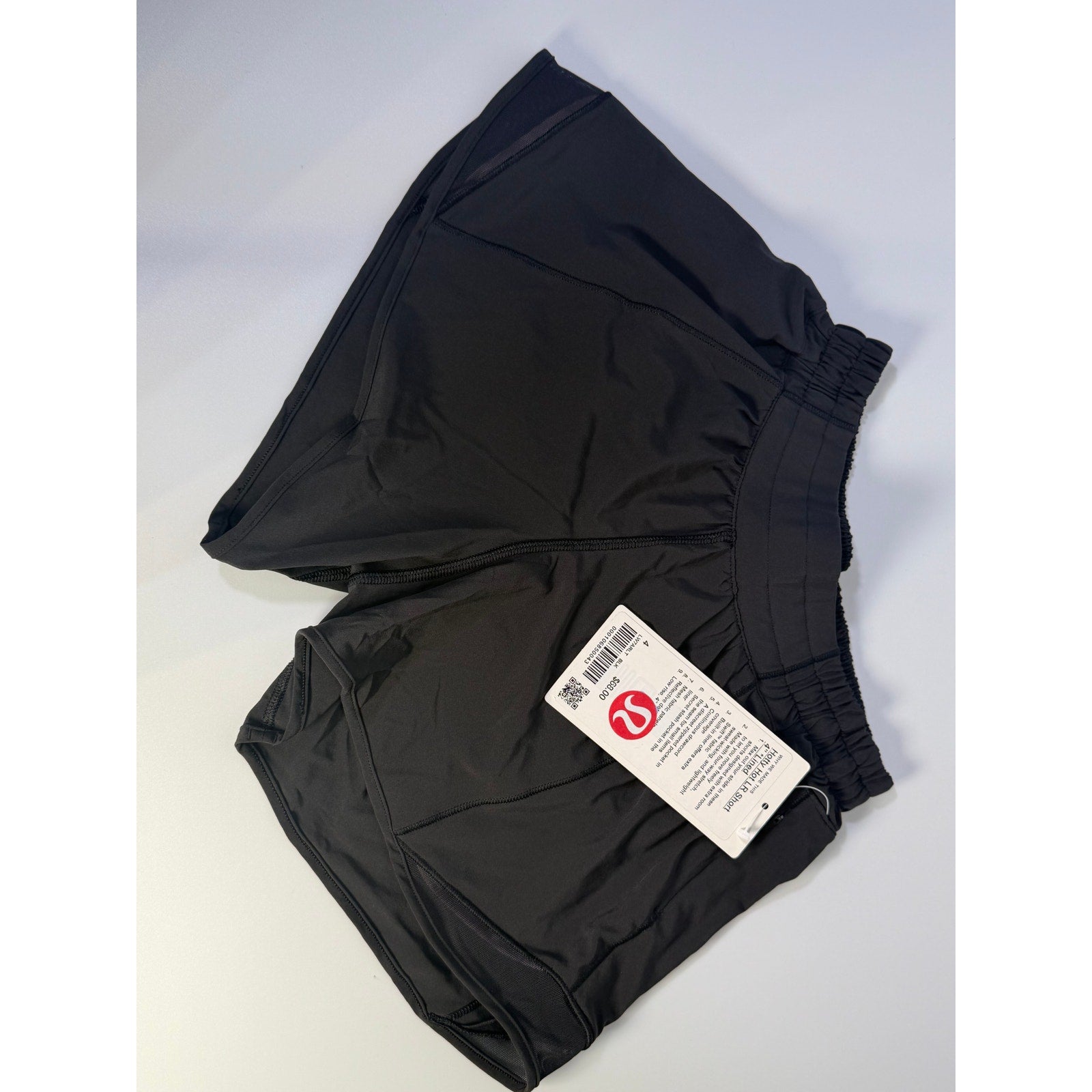 Lululemon Hotty Hot low rise lined shorts in black, women's size 4, with a 4-inch inseam, front view showing lightweight athletic fabric.