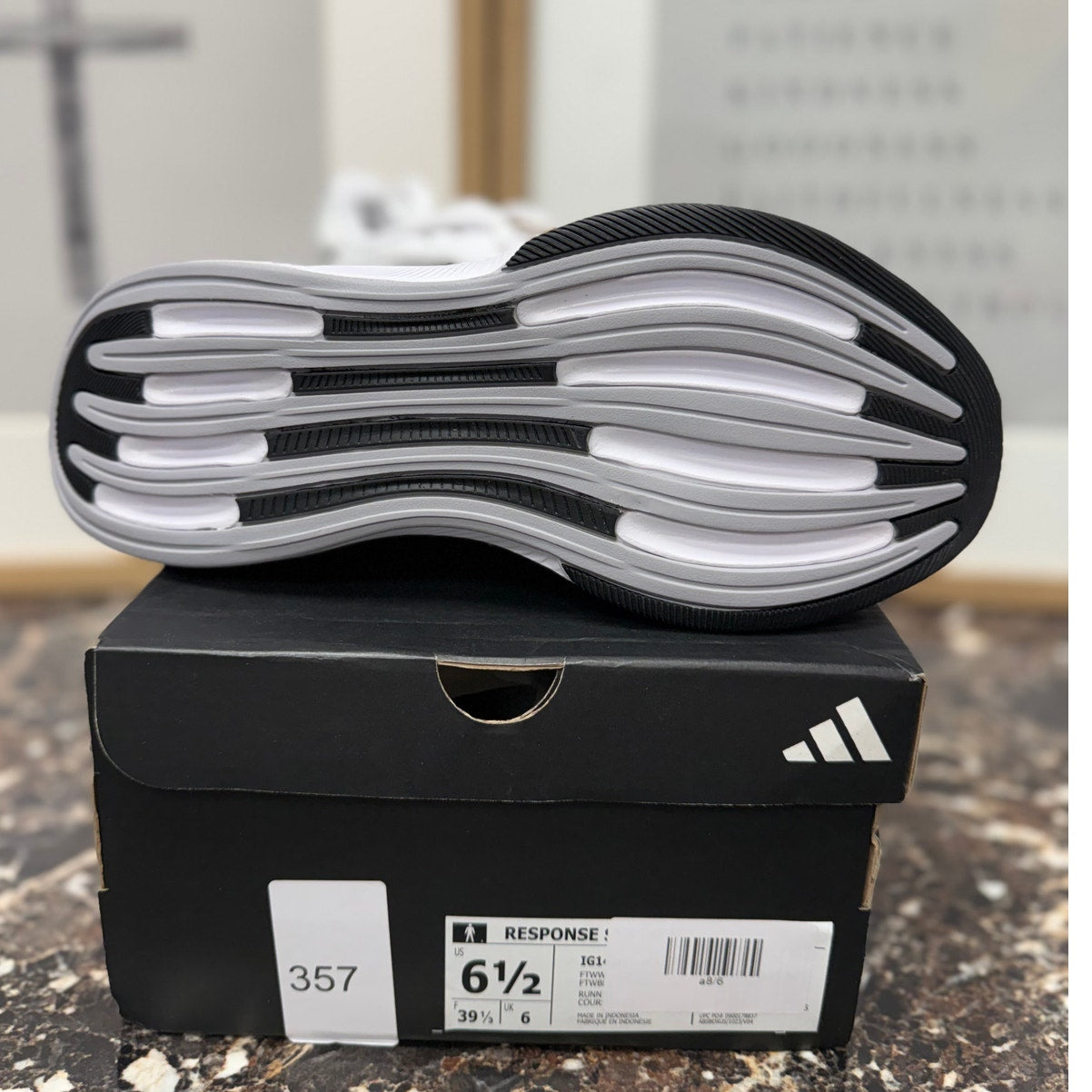 Adidas Response Super women's running sneakers in white, black, and silver with cushioned soles and breathable mesh upper.