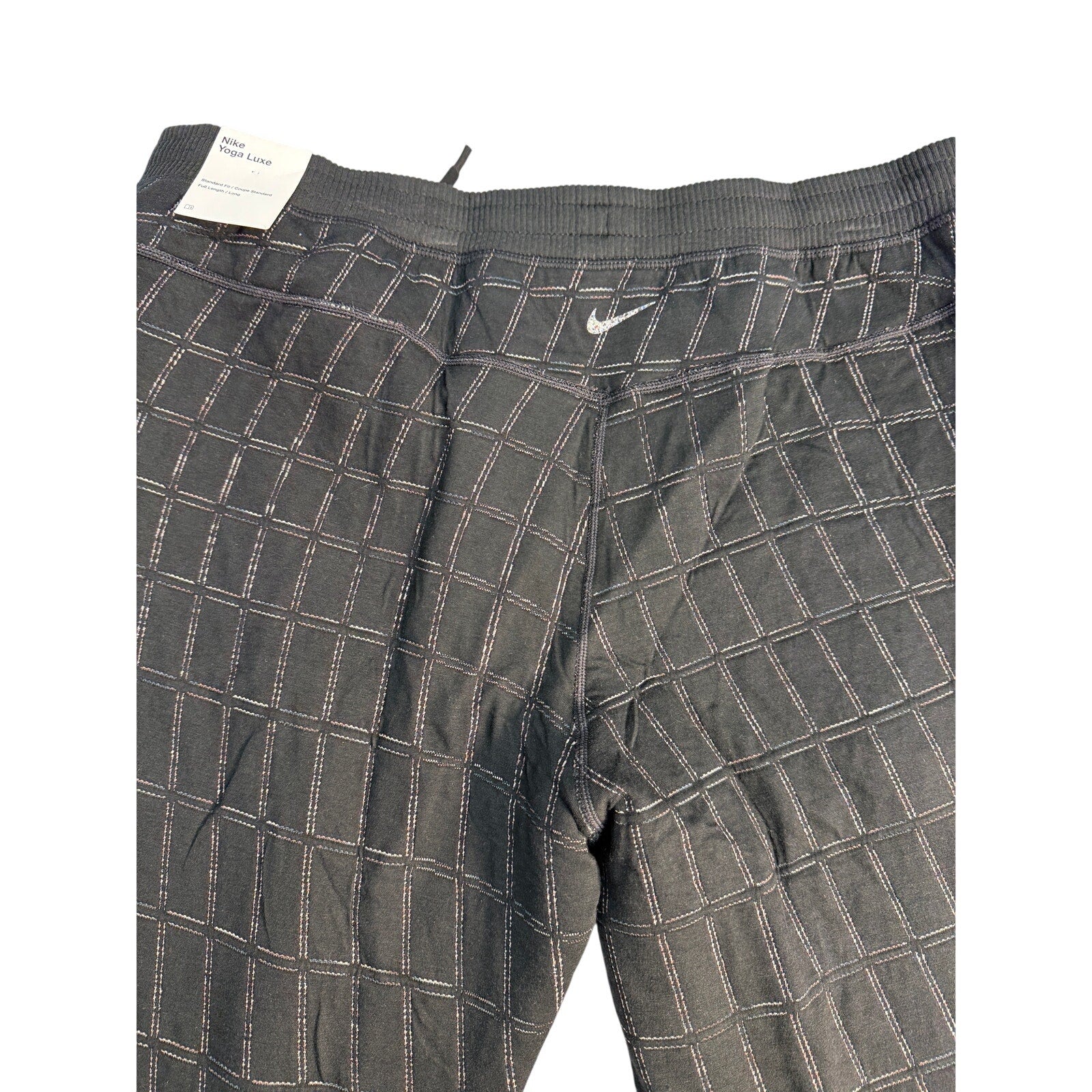 Black Nike Yoga Luxe Dri-FIT Grid jogger pants for women, showing the relaxed fit and elastic waistband.