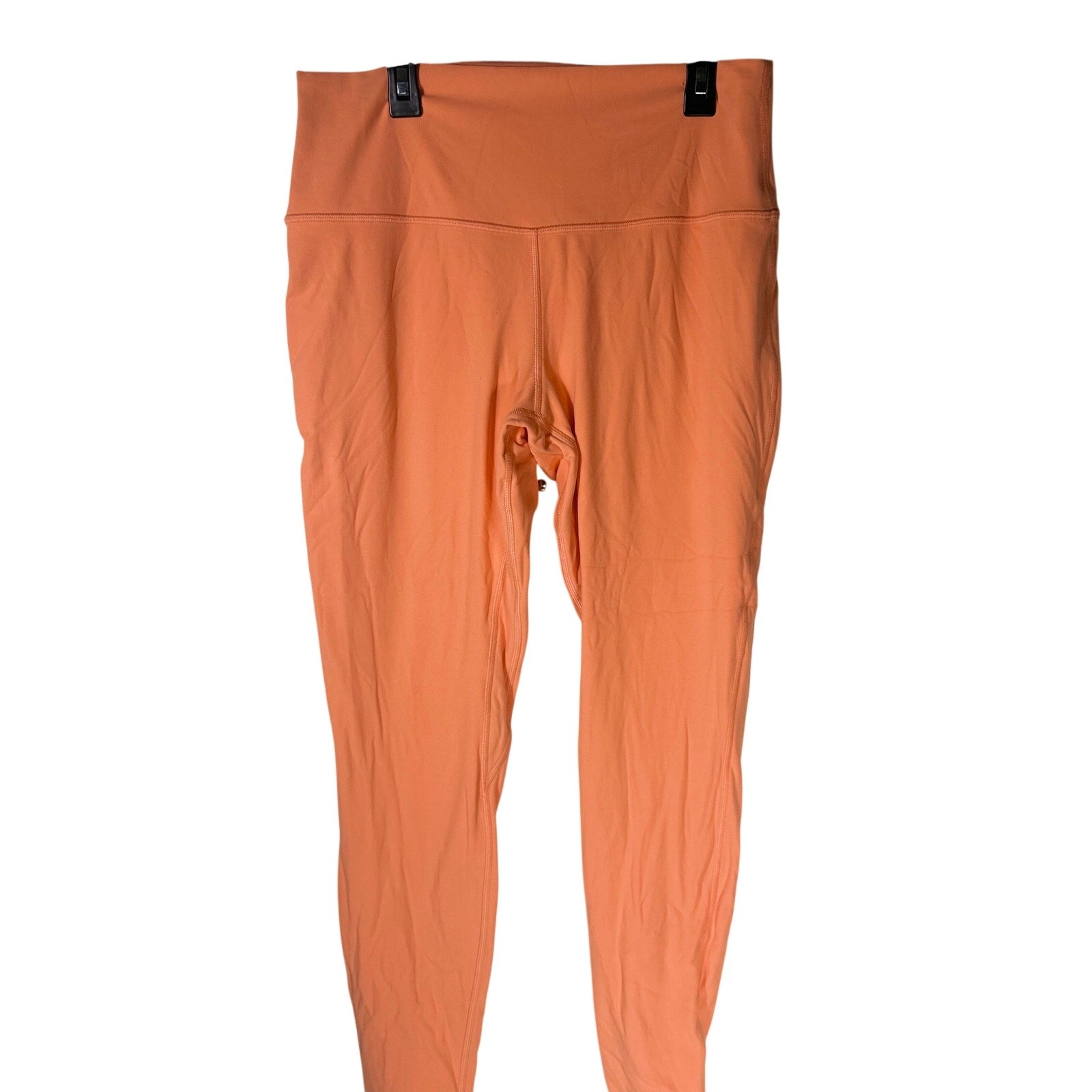 Lululemon women's high-rise burnt orange leggings, size 12, shown laid flat with smooth fabric and comfortable fit.