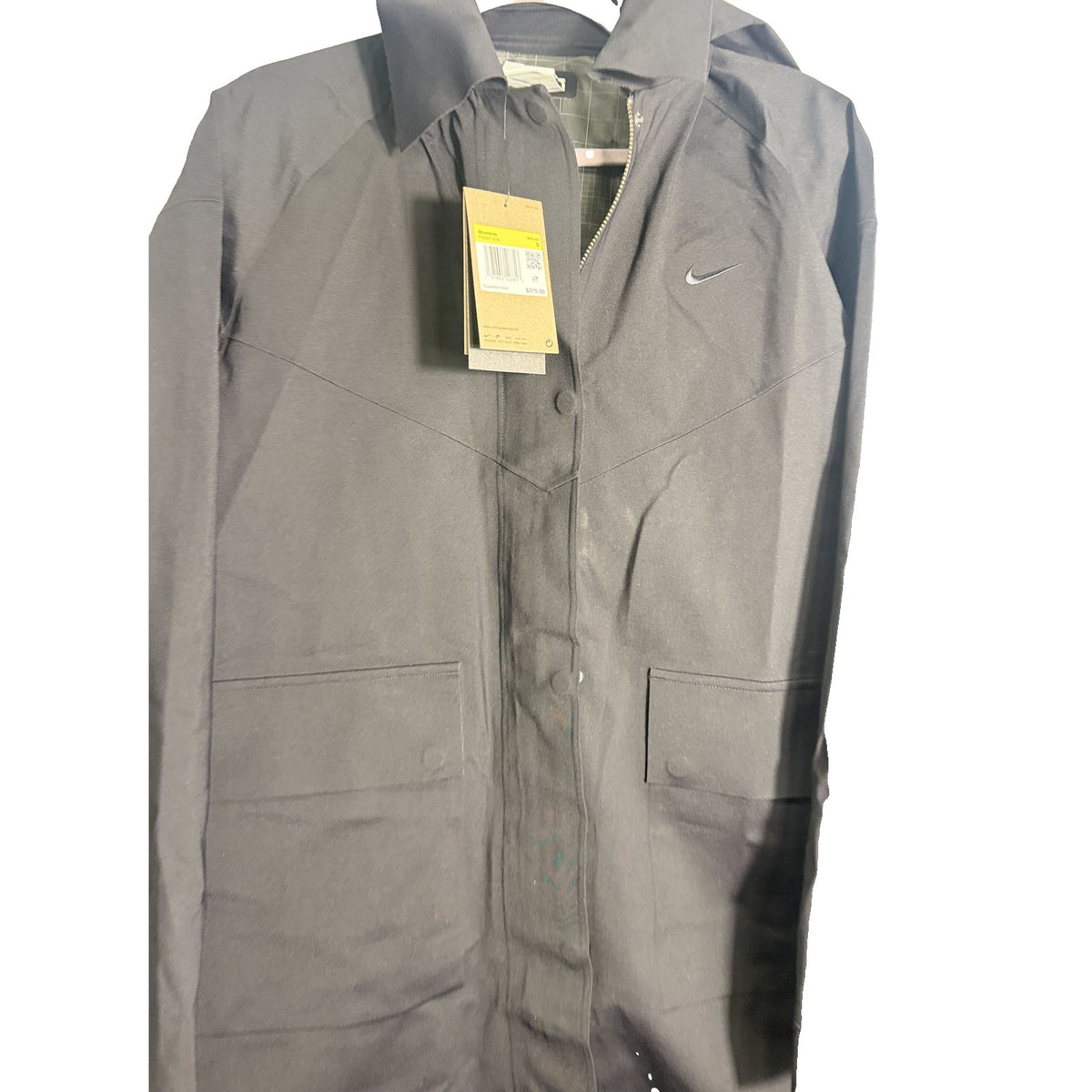 Nike Storm-FIT ADV long trench coat for women in black, showing the sleek design and waterproof fabric, size small.