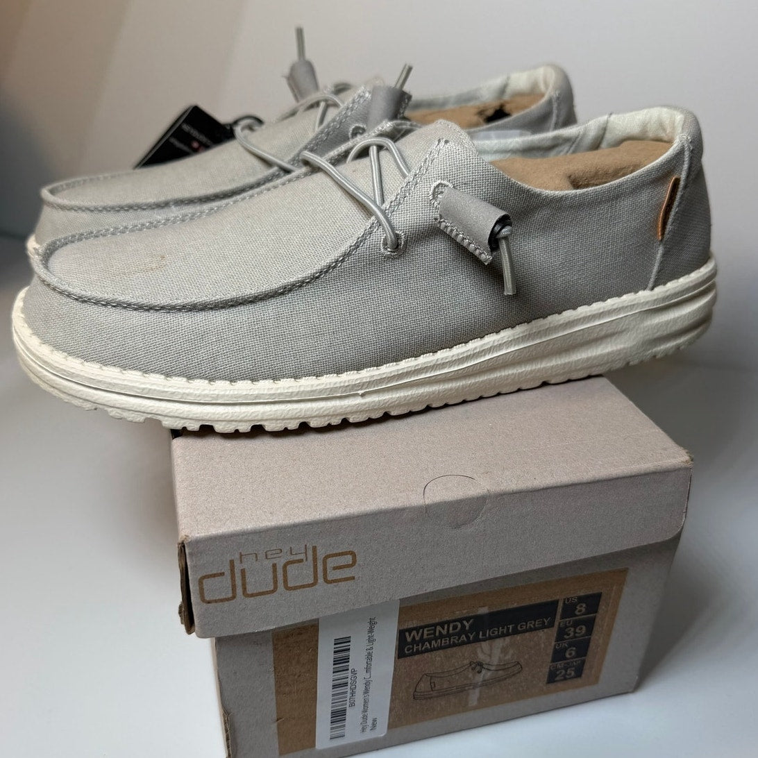 Light grey Hey Dude Wendy Chambray sneakers for women, size 8, featuring casual slip-on design and comfortable fabric upper.