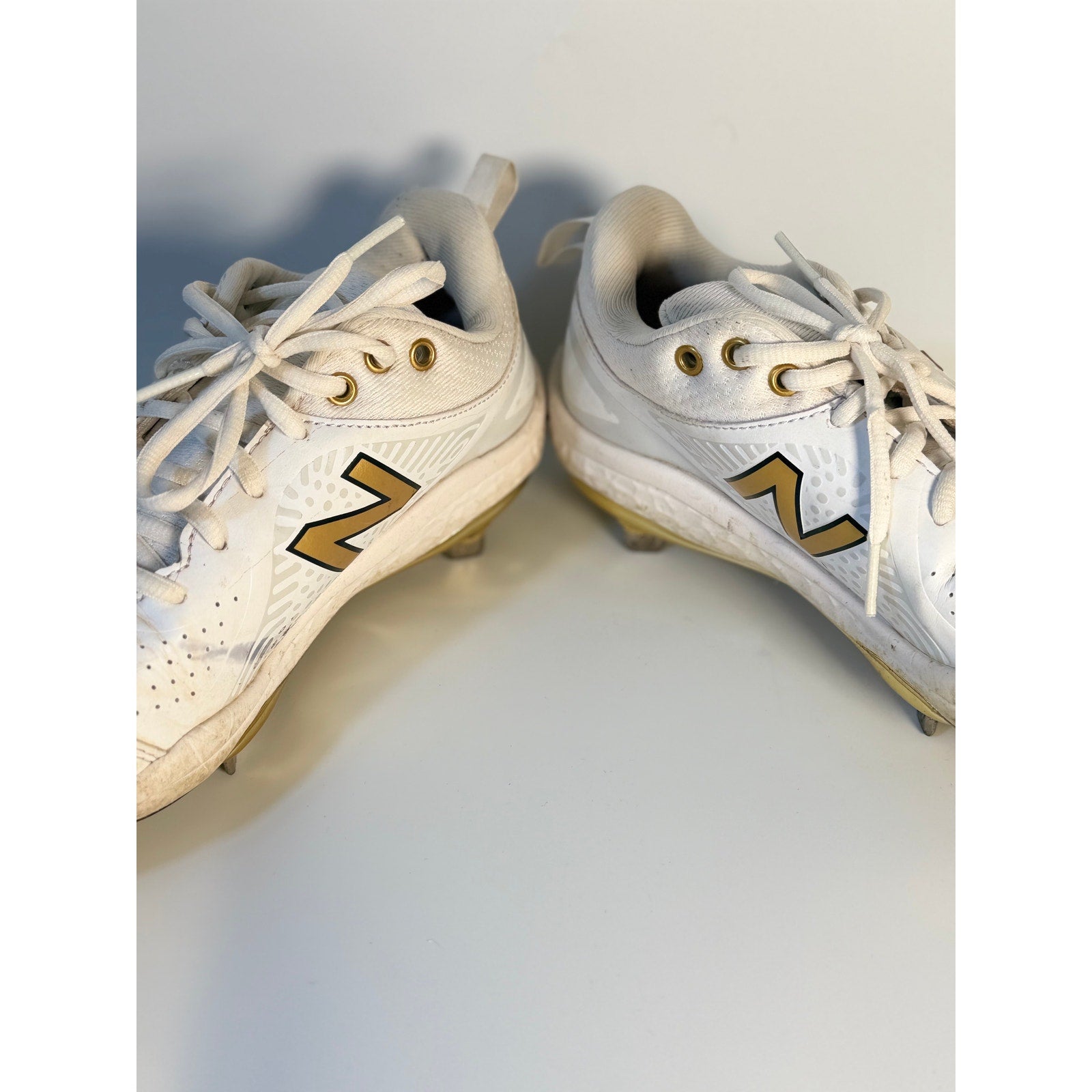 New Balance FuelCell COMPv2 baseball cleats in white and gold, men's size 7.5, with metal cleats and sporty design