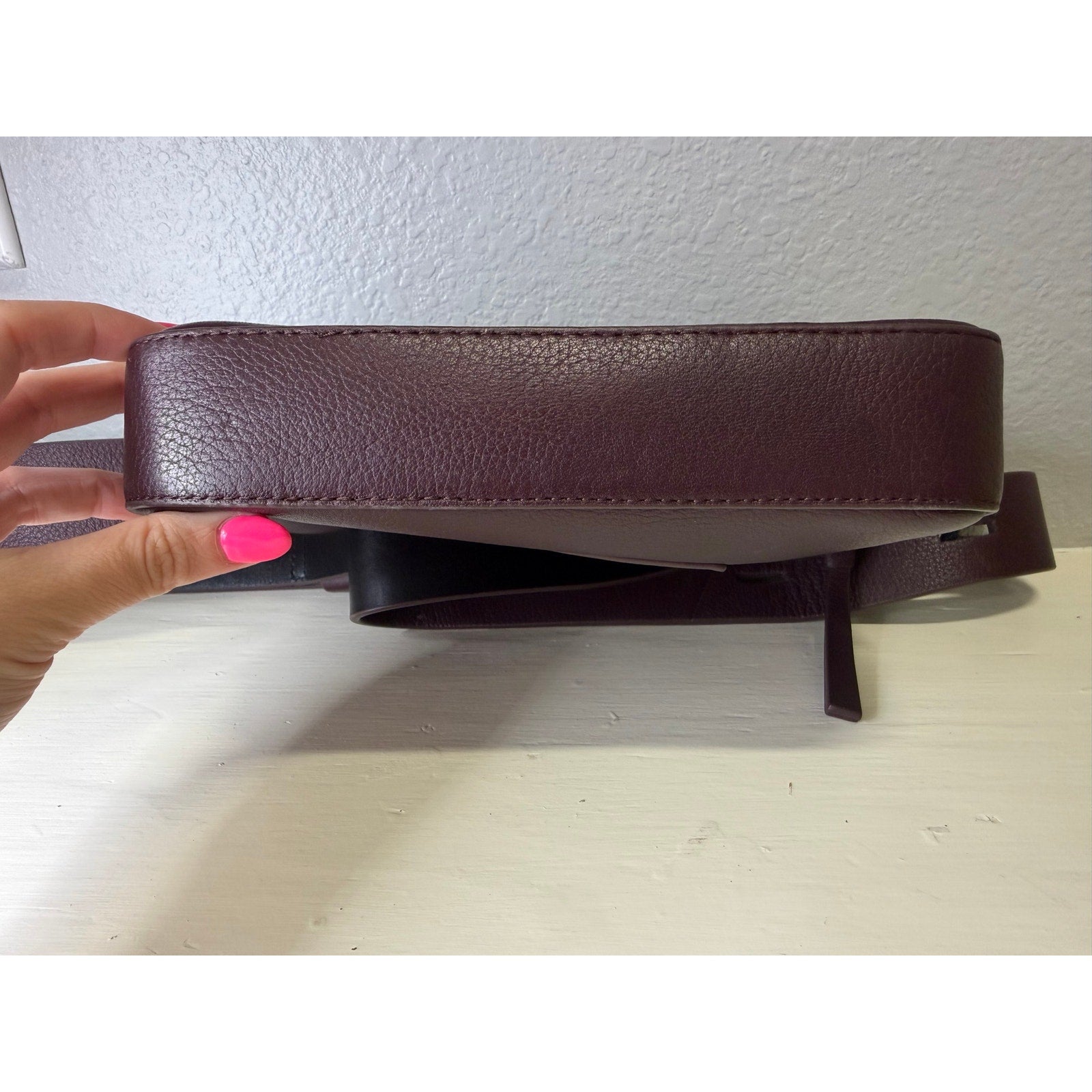 AllSaints women's burgundy pebbled leather camera crossbody bag with adjustable strap, stylish handbag for everyday use.