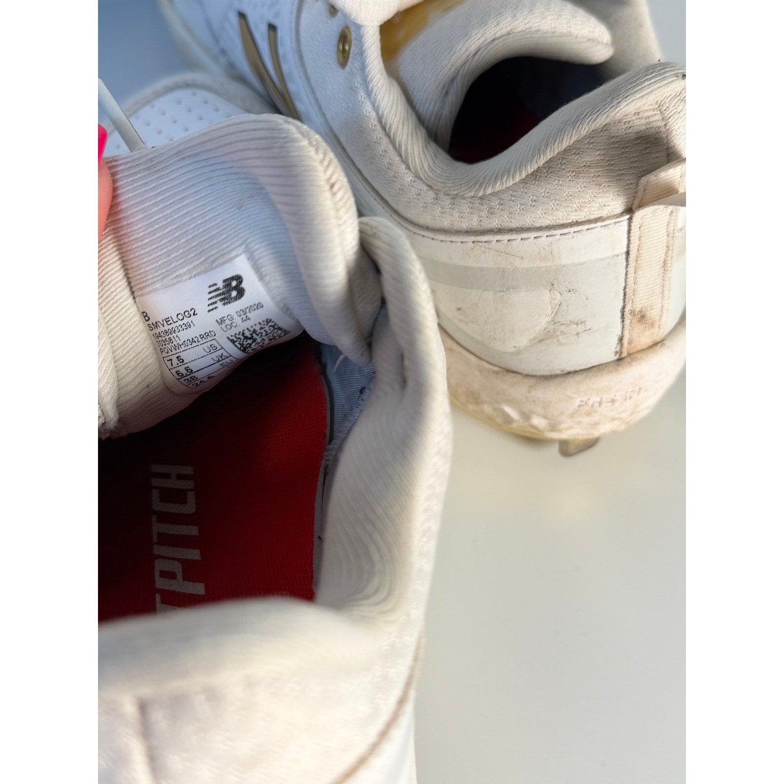 New Balance FuelCell COMPv2 baseball cleats in white and gold, men's size 7.5, with metal cleats for enhanced traction.